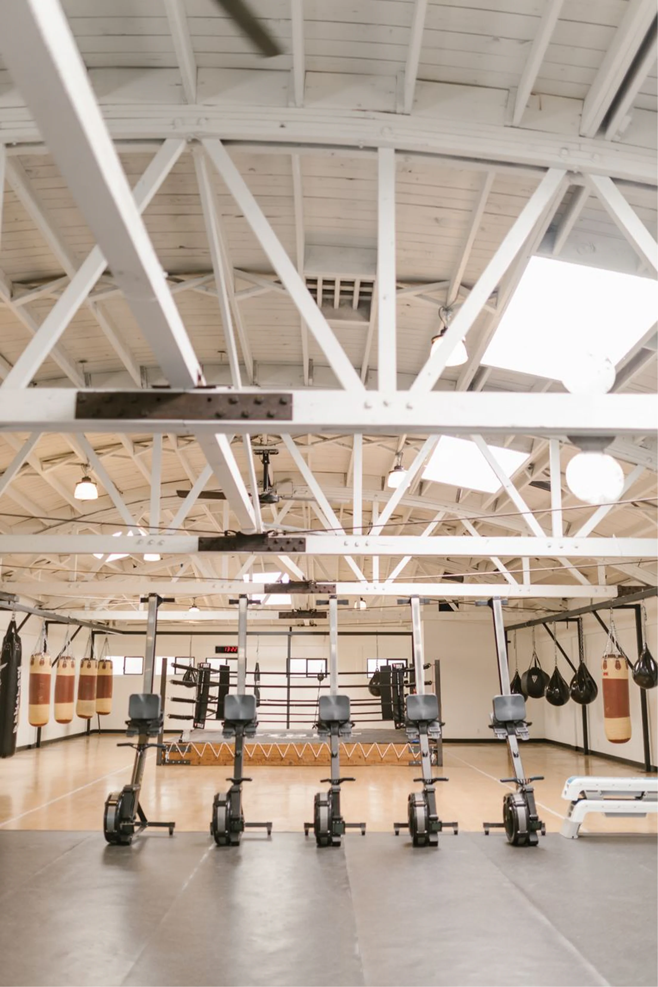 Modern martial arts training facility with boxing bags, training equipment and open floor space at Rai Martial Arts.