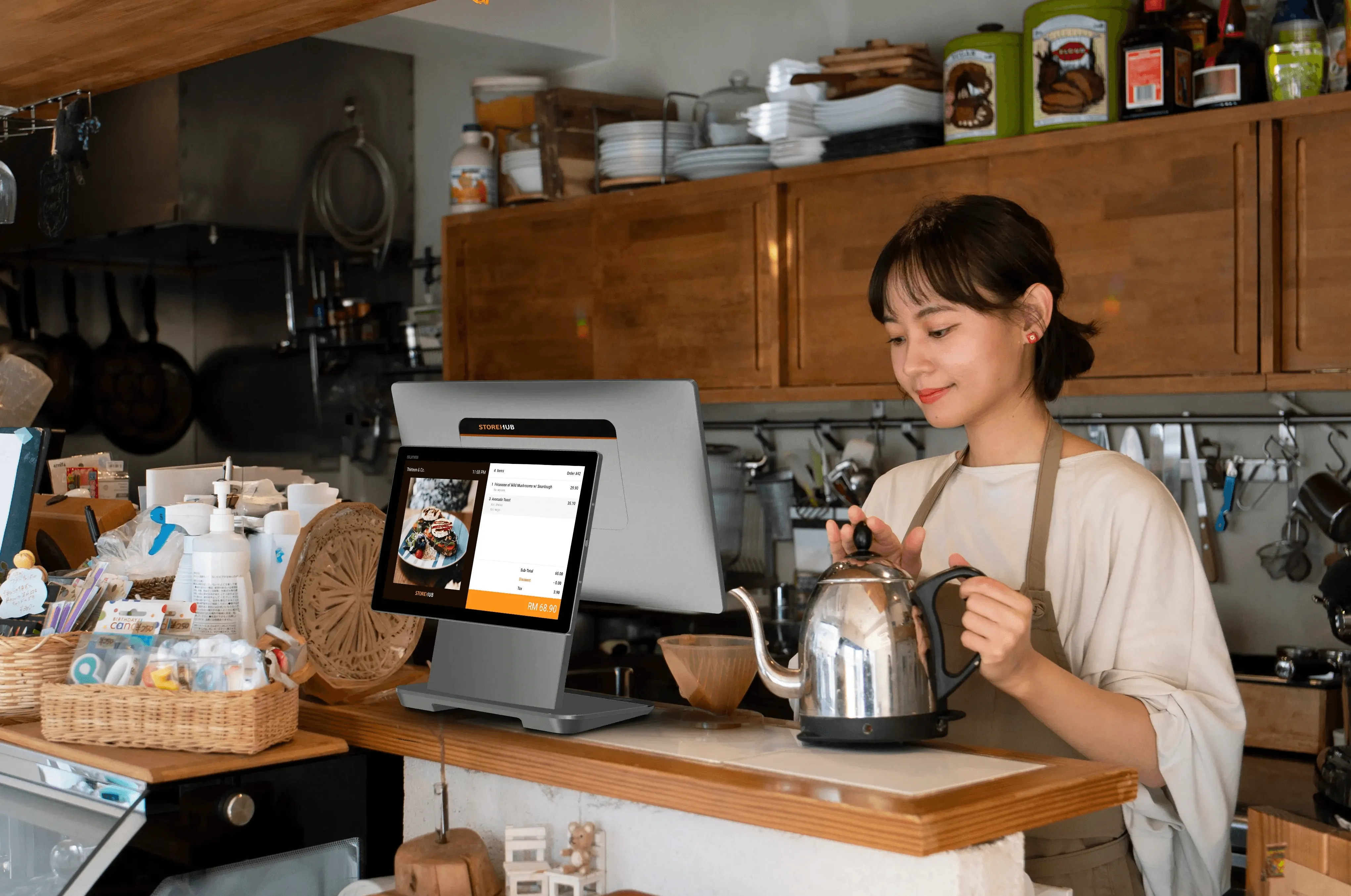 Malaysian cafe staff using the StoreHub cloud-based POS system to manage orders and payments.