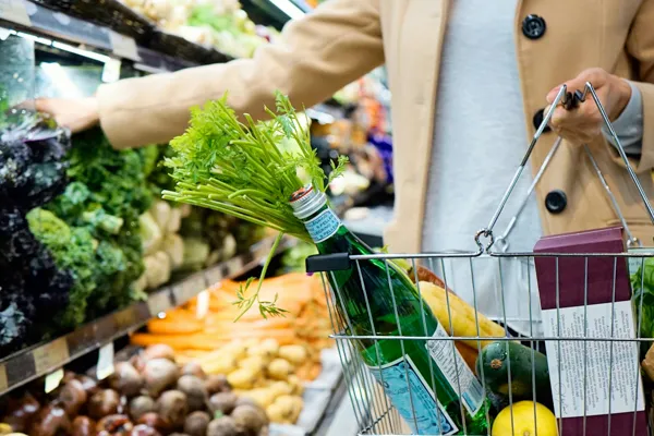 Pessoa a fazer compras no mercado com cesto na mão — apoio a idosos nas idas às compras · Táxi Afonso · 11 Moledo e Cristelo