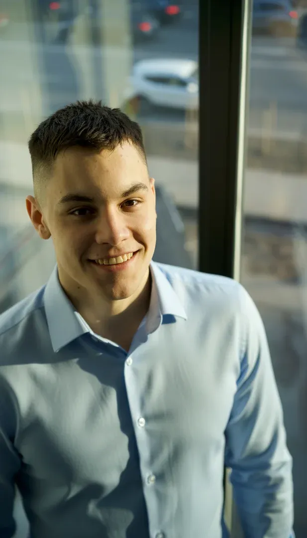 Portrait of a laughing person with curly hair wearing a white shirt