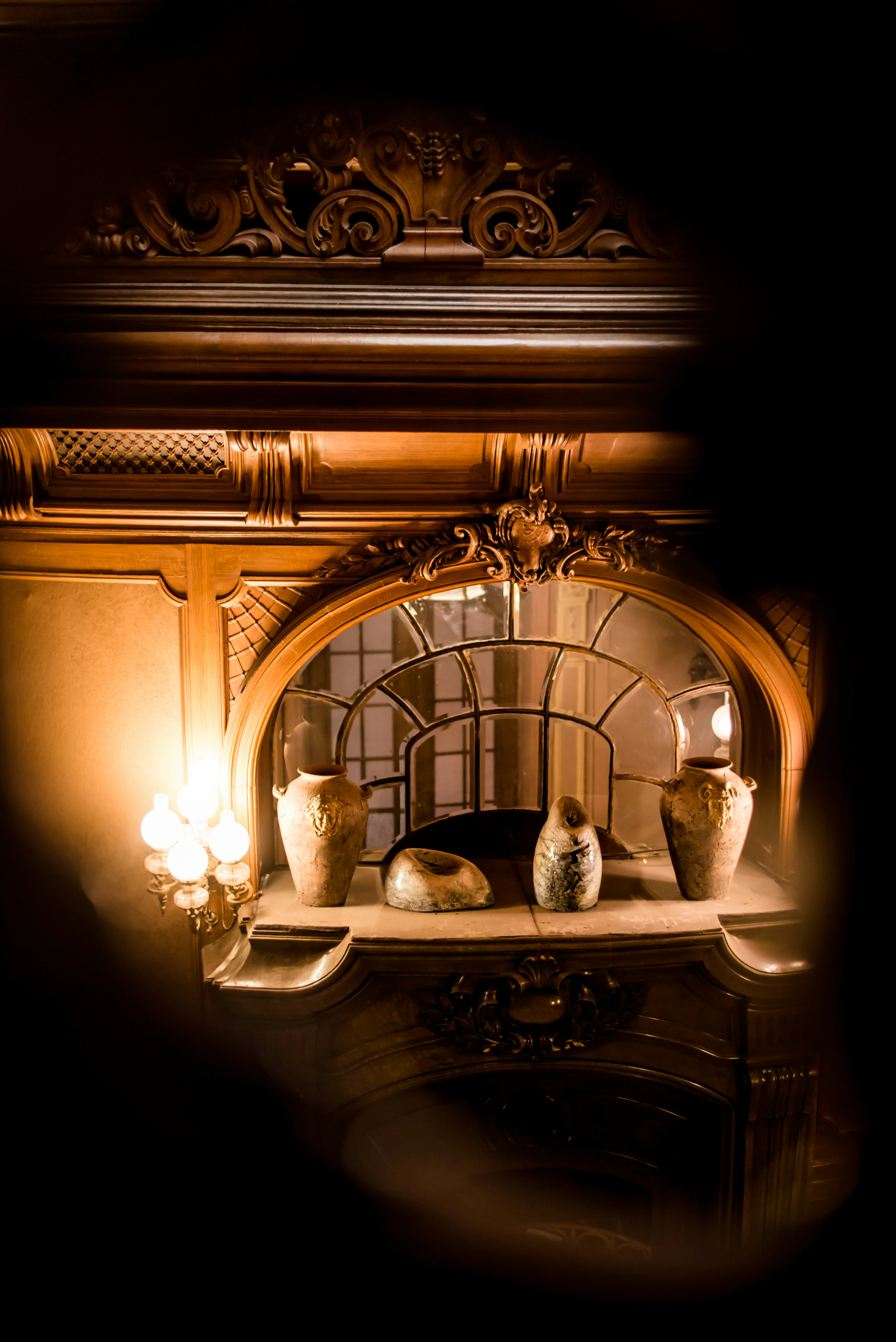 An antique decorative piece in a dark room illuminated by candlelight.