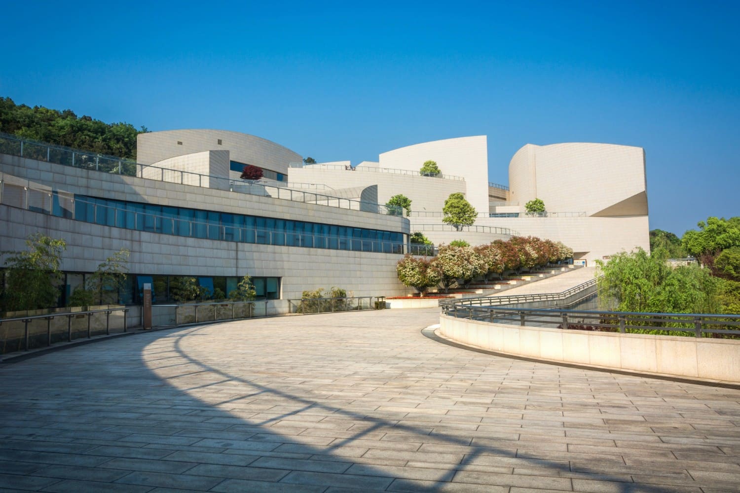 Terracotta stucco space with intersecting arches and warm sunlight creating geometric shadows.