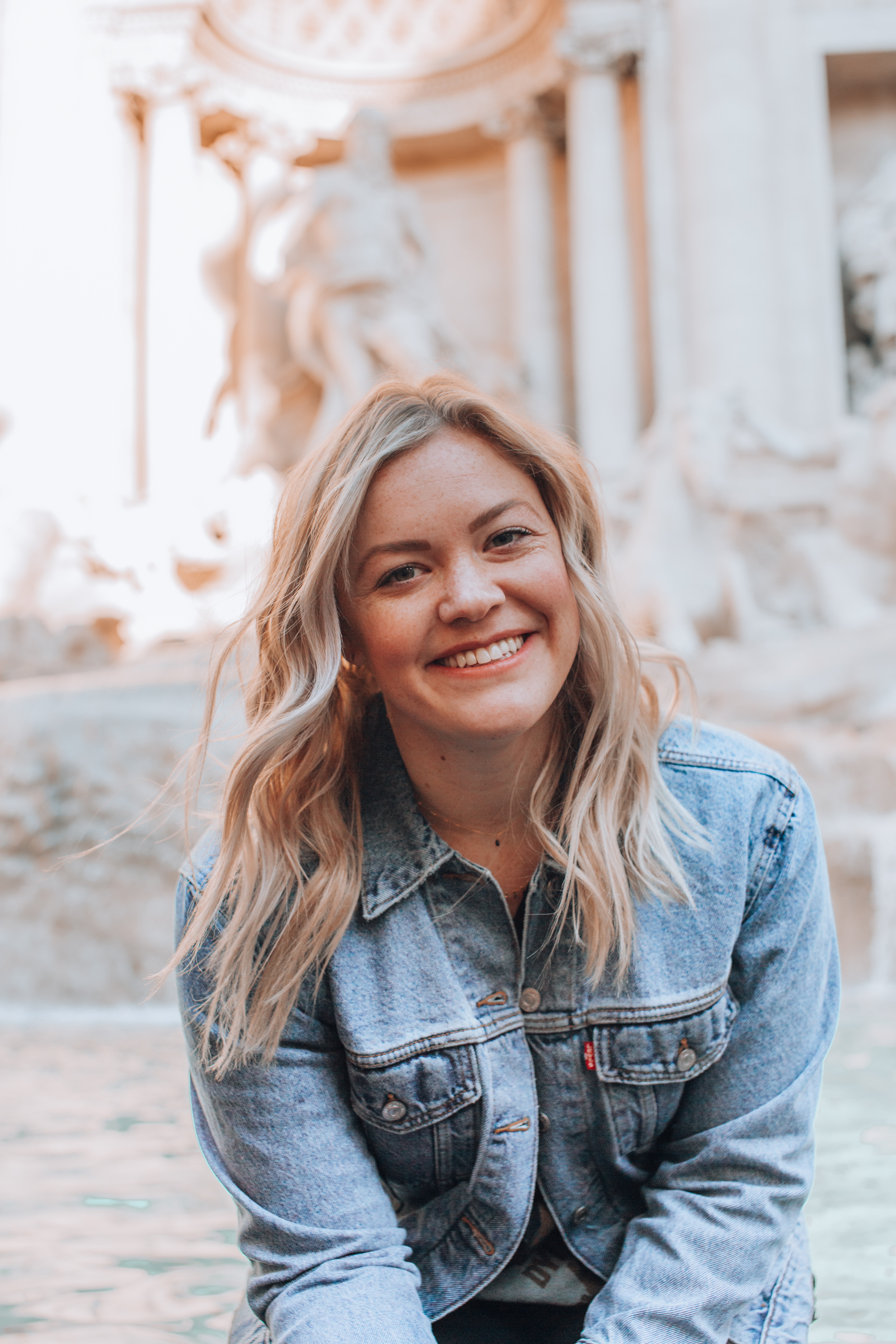 Blonde woman smiles outside