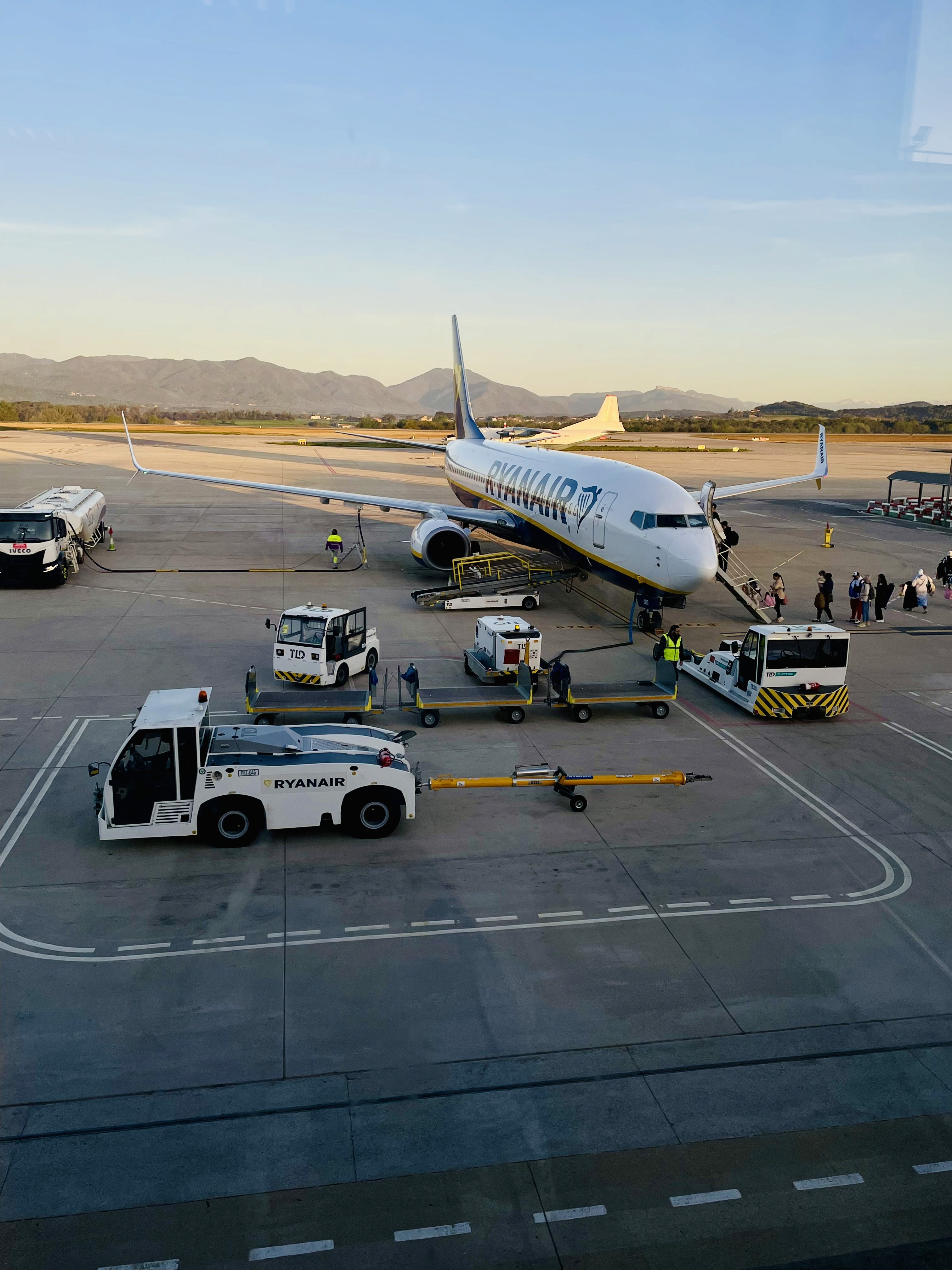 A man wearing sunglasses and a t-shirt stands against blue.