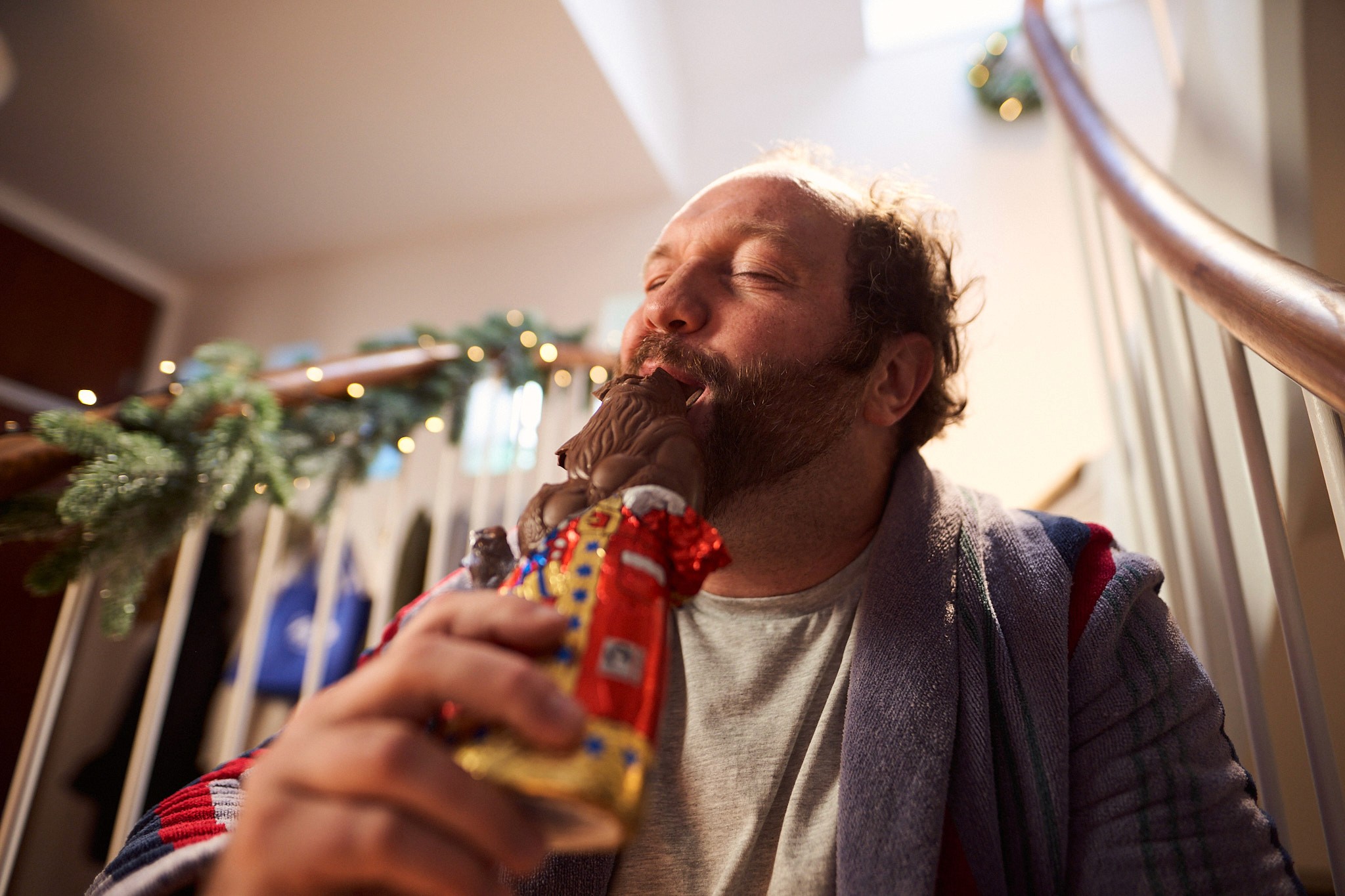 Man enjoying a chocolate Santa during the festive season in ALDI’s Christmas campaign.