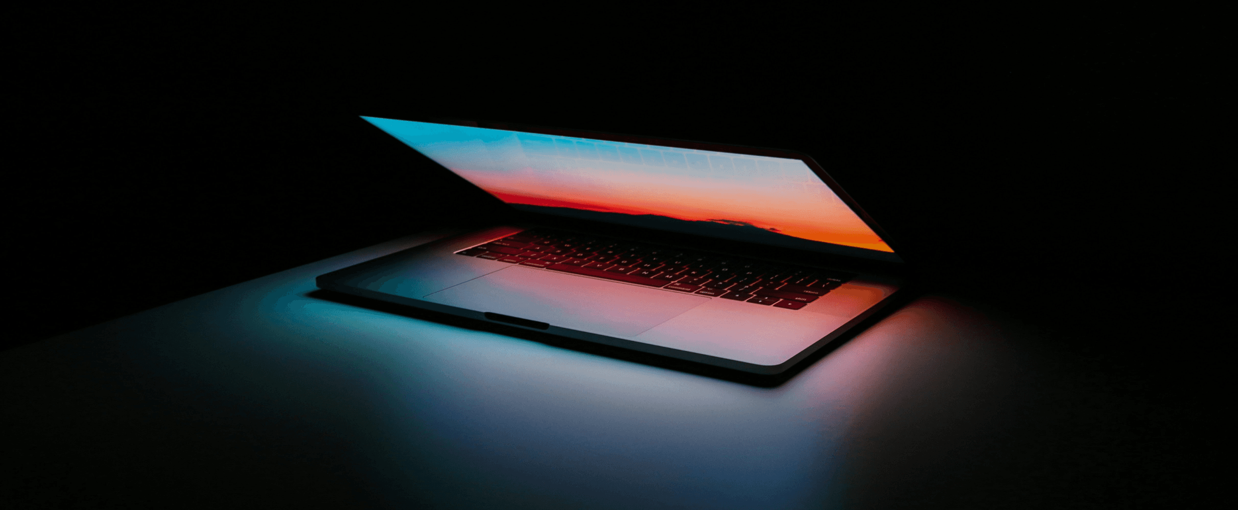 An almost closed laptop with a brightning orange screen, the rest is entirely black. High quality.