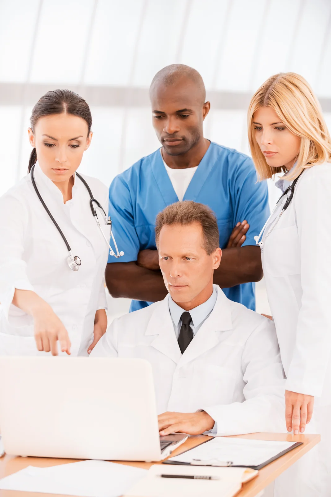 Medical Professionals Collaborating with Laptop in Office