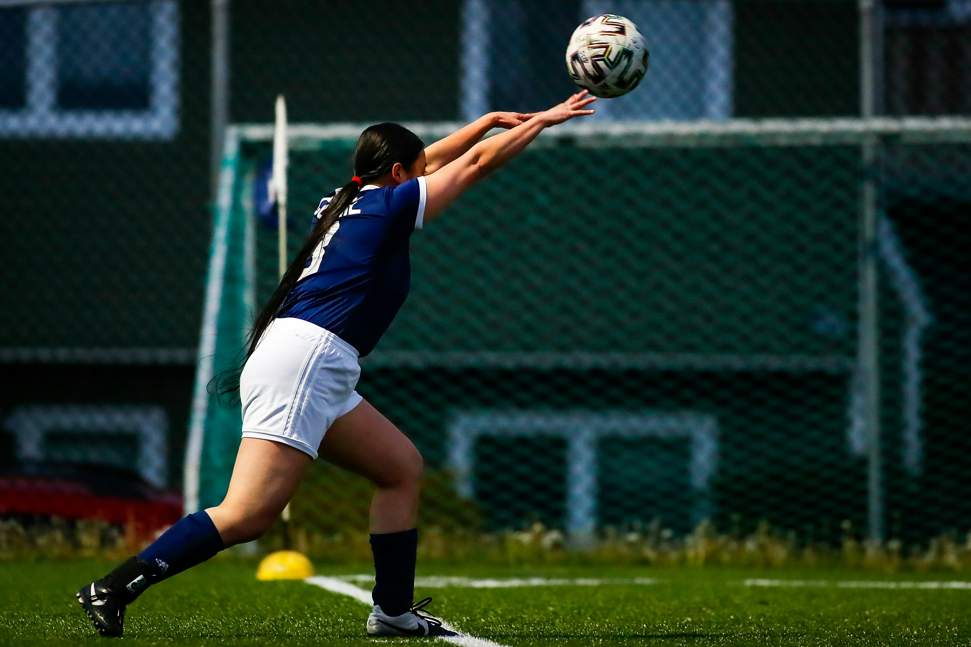 woman in blue and white jersey shirt and white shorts playing soccer during daytime