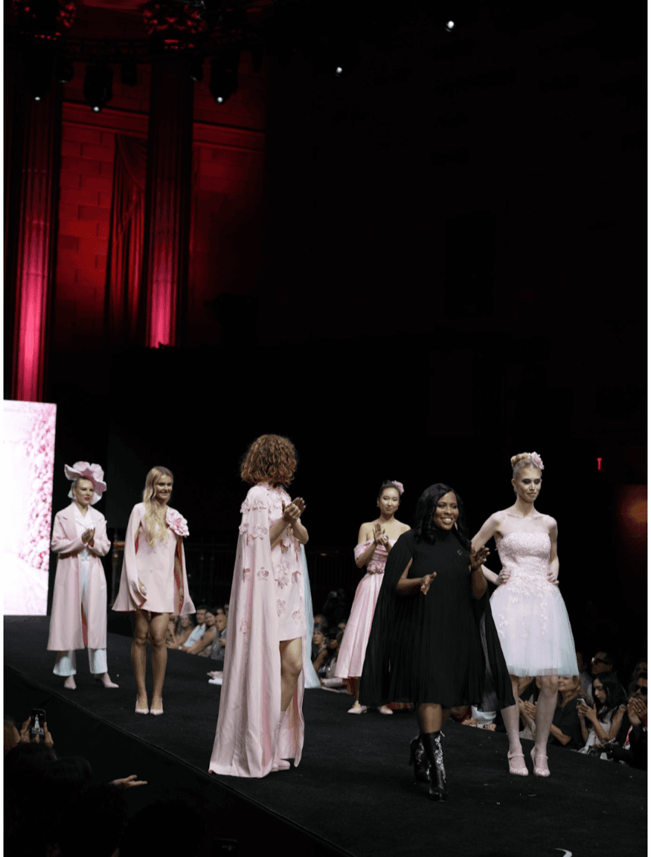 Katrina Frazier walking the runway alongside models wearing pink designs at a fashion show.