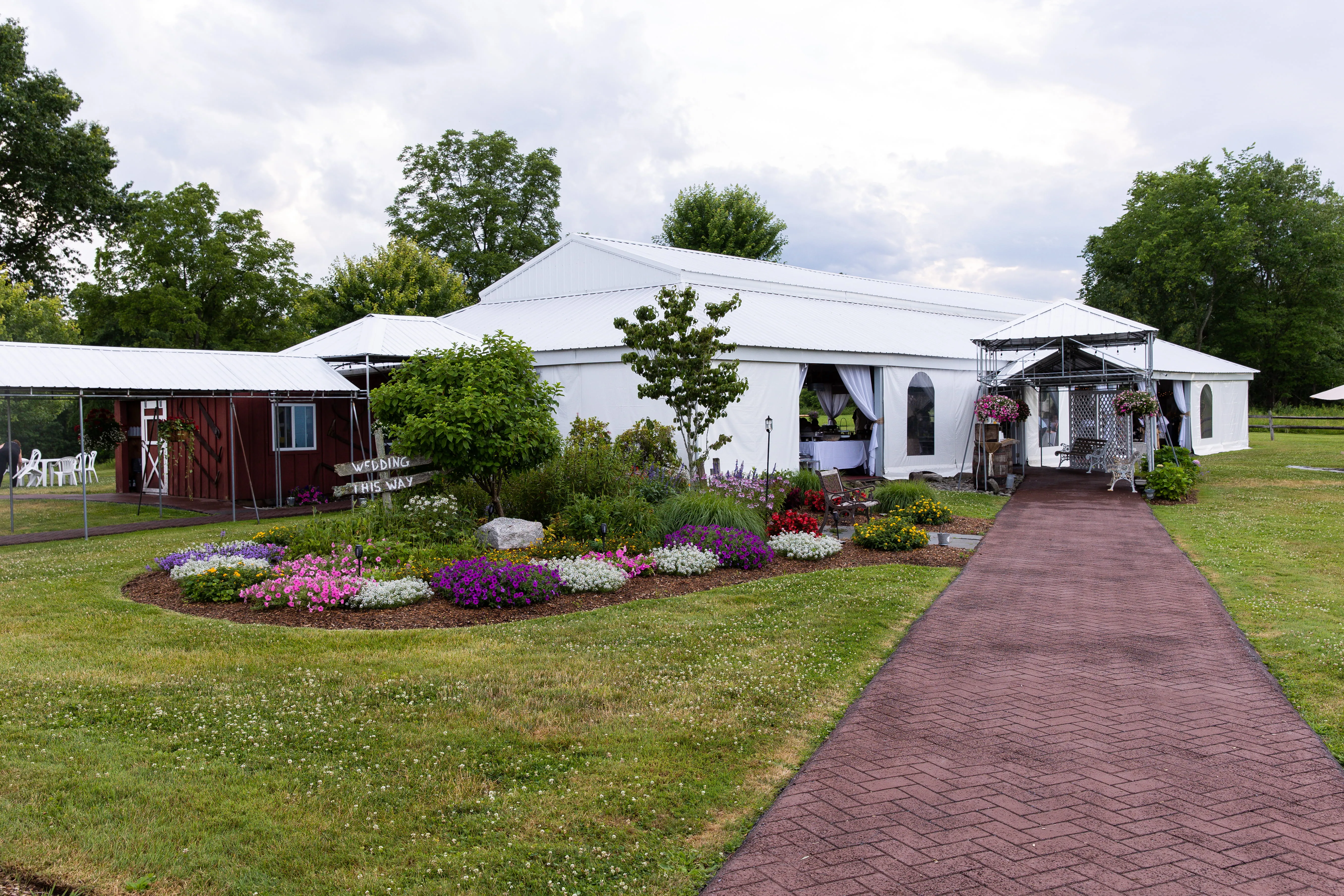 Outdoor wedding reception tent setup with lighting and landscaping