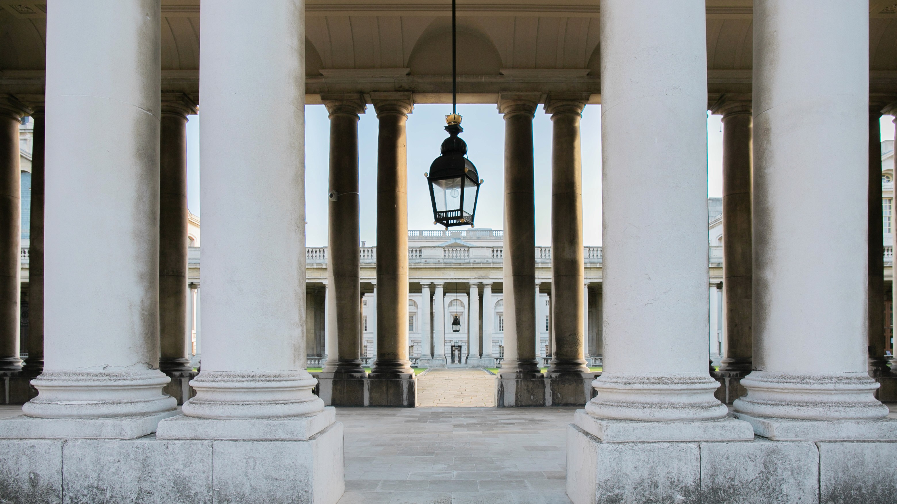 Two classic volkswagen beetles, one green, one cream.