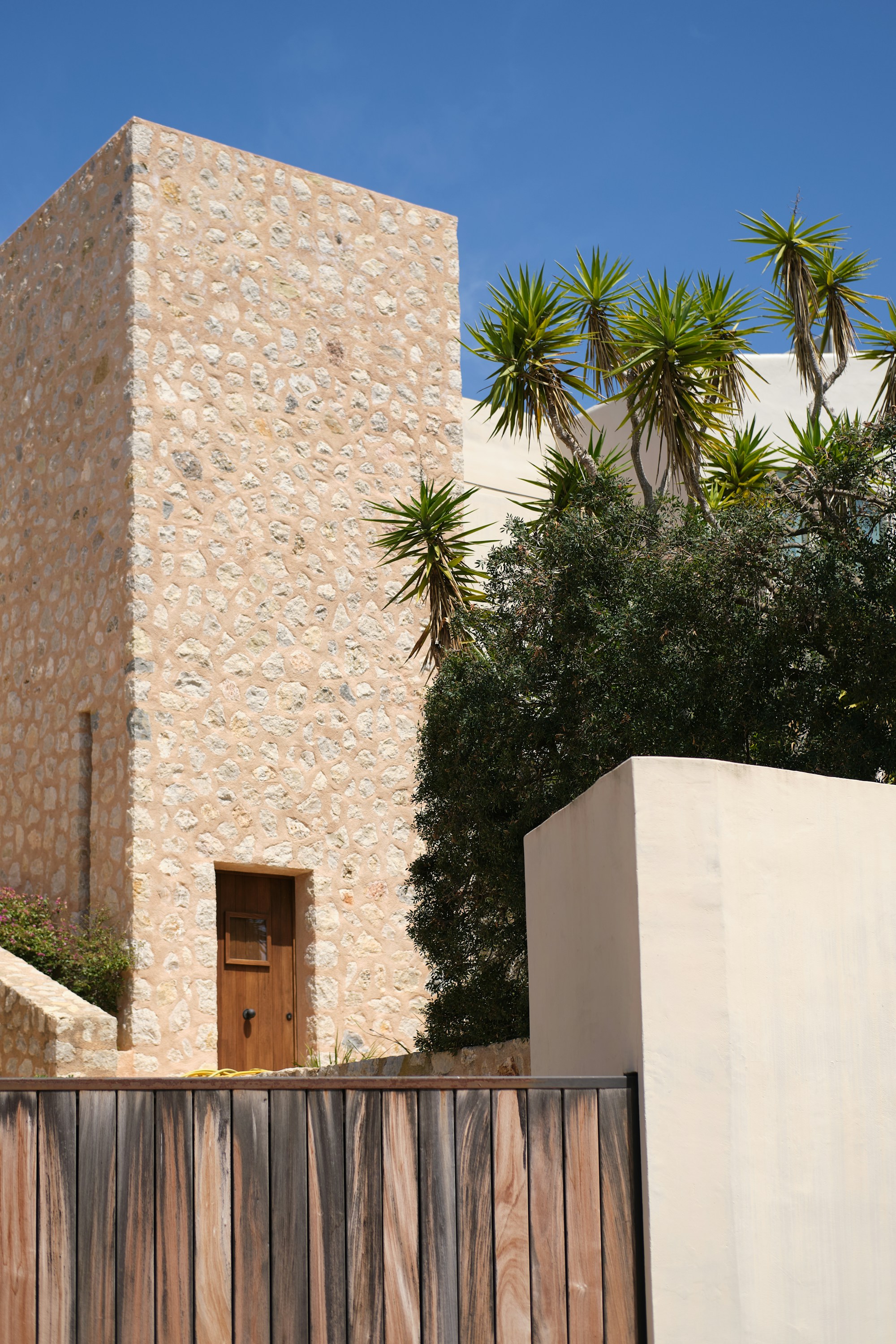 Natural stone facade beside mature greenery