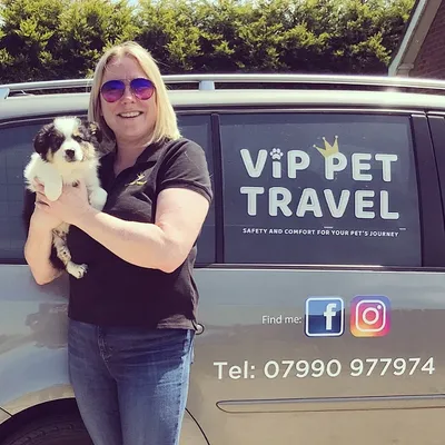 Esther holding a puppy next to branded VIP Pet Travel Van ready for a safe and comfortable journey