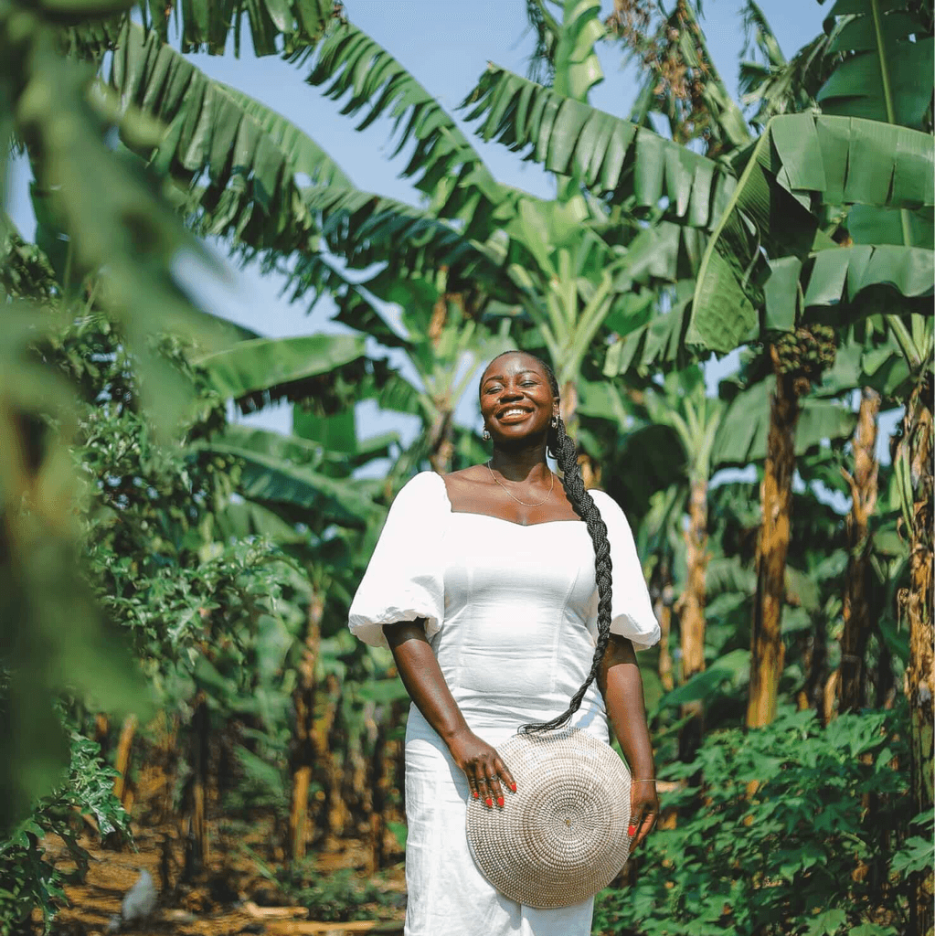 Mary Consolata Namagambe enjoying the sunshine and palm trees in a tropical location in Africa