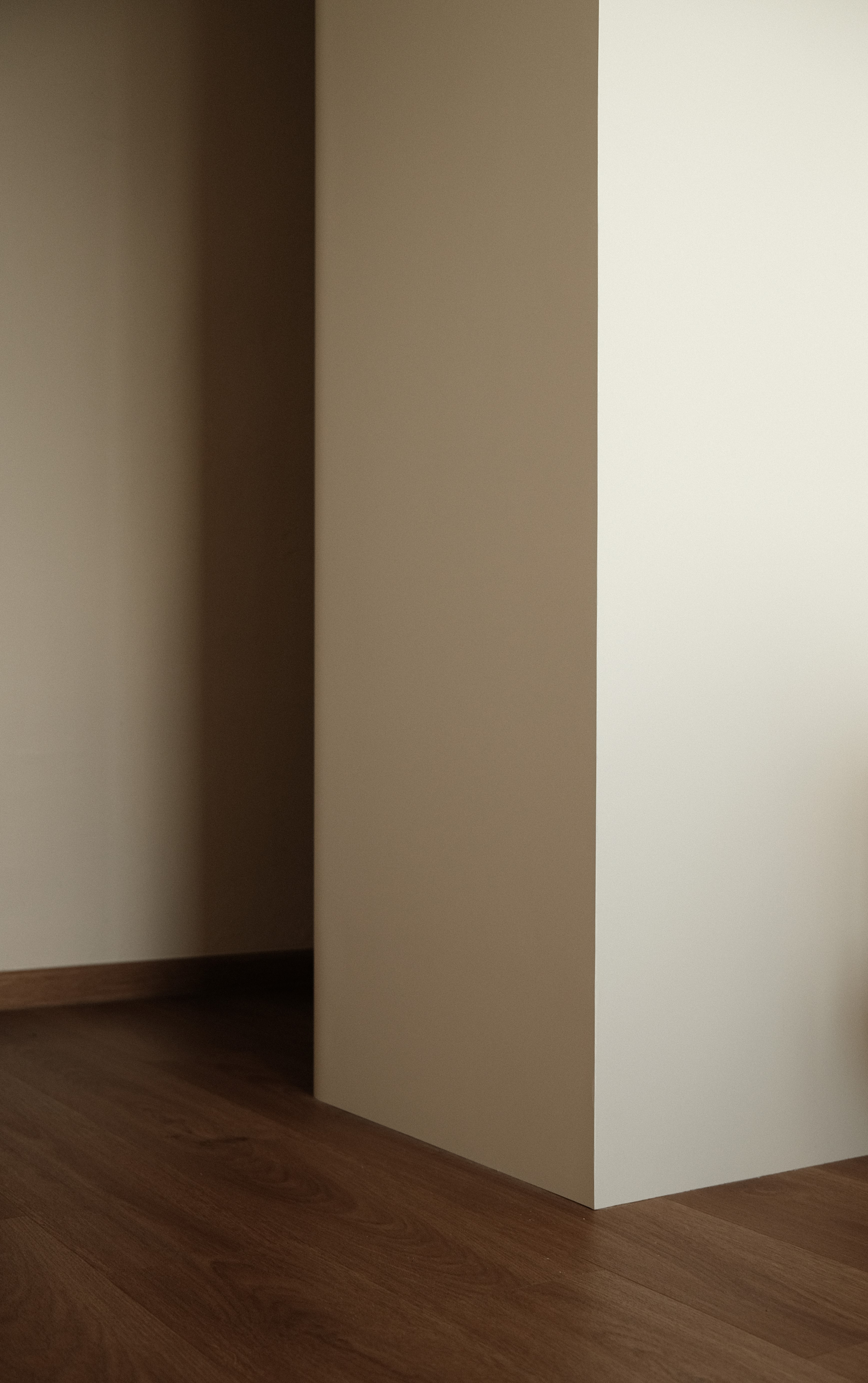 Simple architectural detail showing soft beige walls and timber flooring. Clean lines and neutral tones create a calm, minimalist atmosphere.