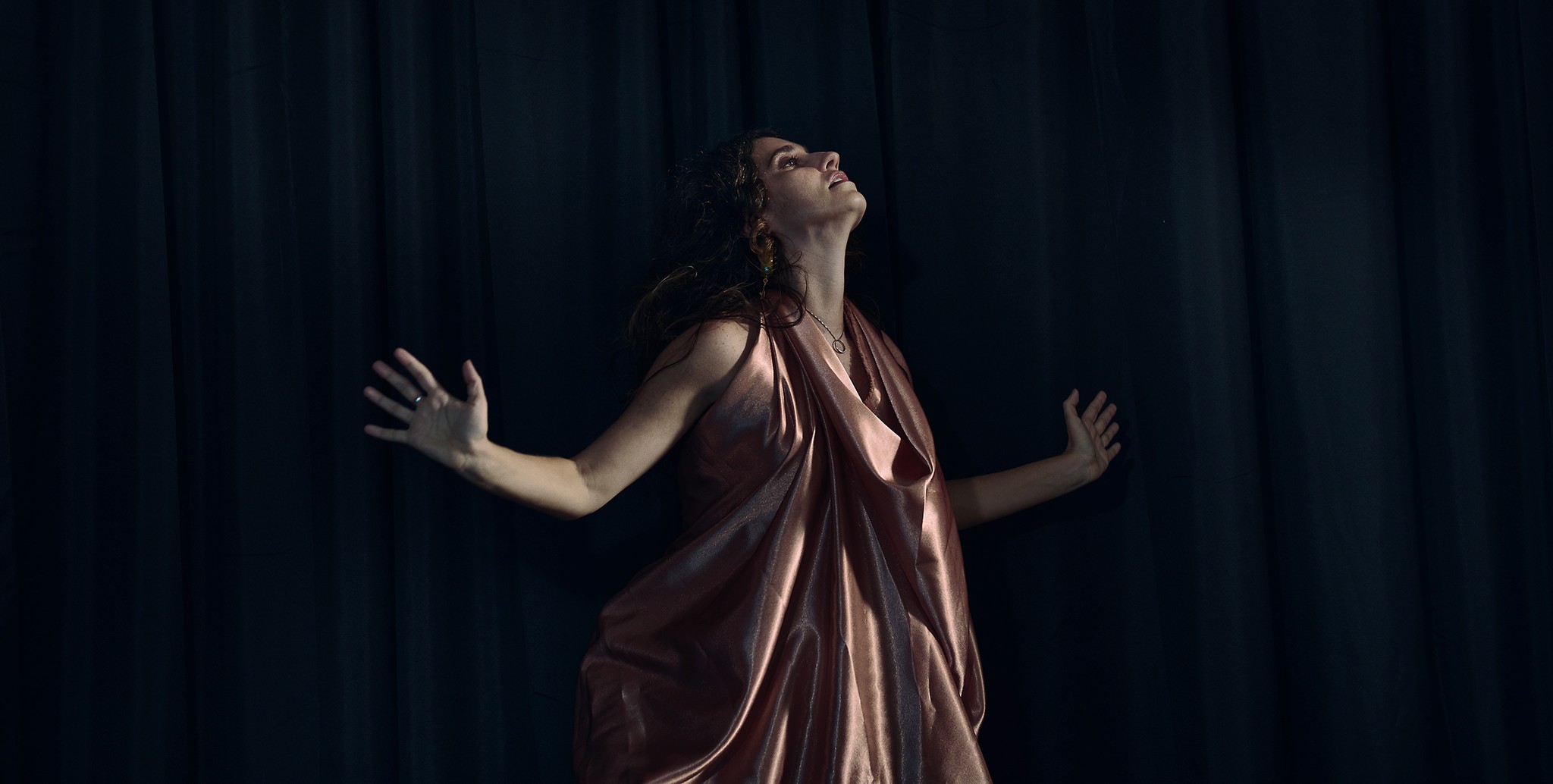 Dancer captured mid performance with artistic and expressive movements against a dark background.