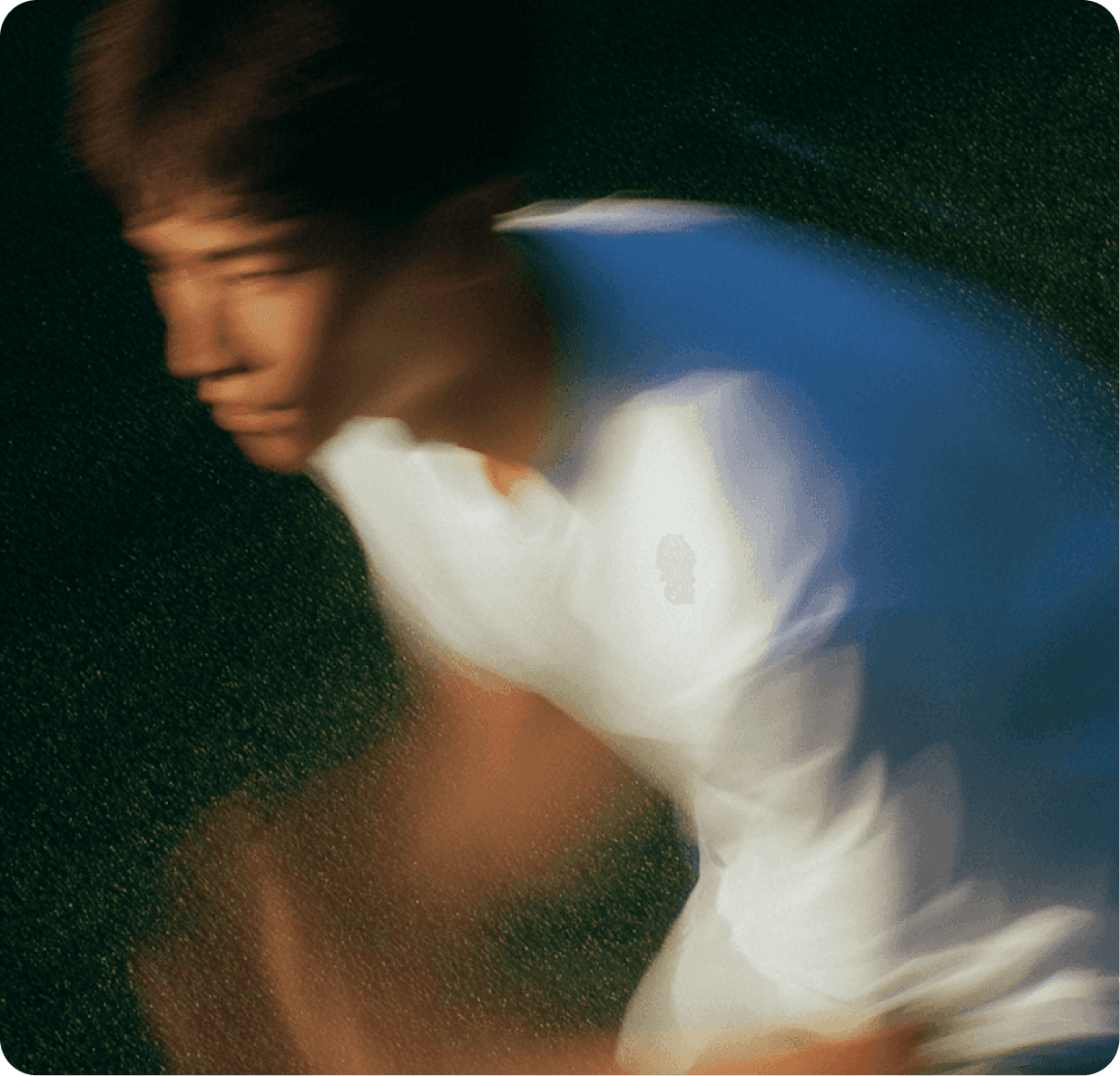 A man in athletic wear serves a tennis ball on a court, focused and ready for the game.
