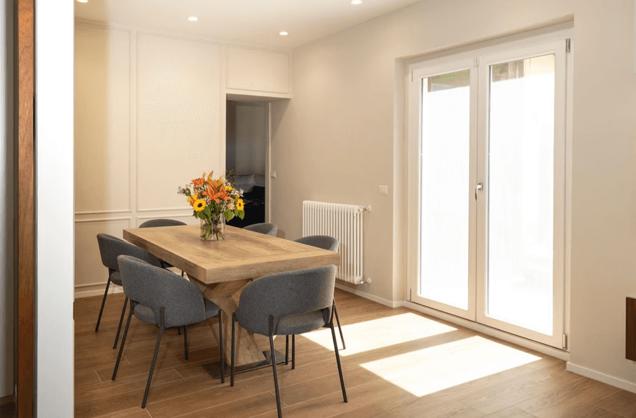 sala con parquet e tavolo in legno illuminata dal sole