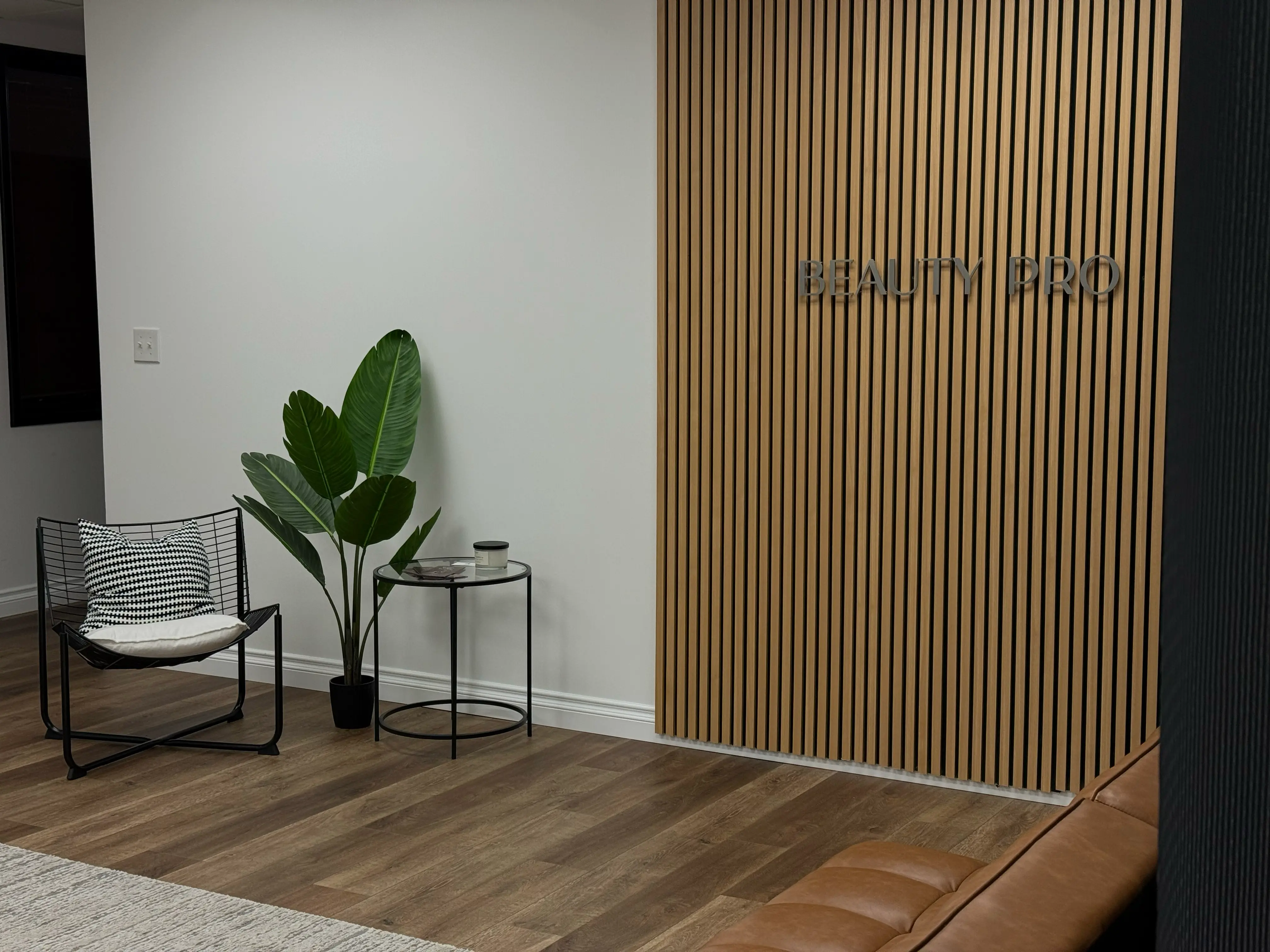 Open coworking area with rows of styling stations and wood flooring