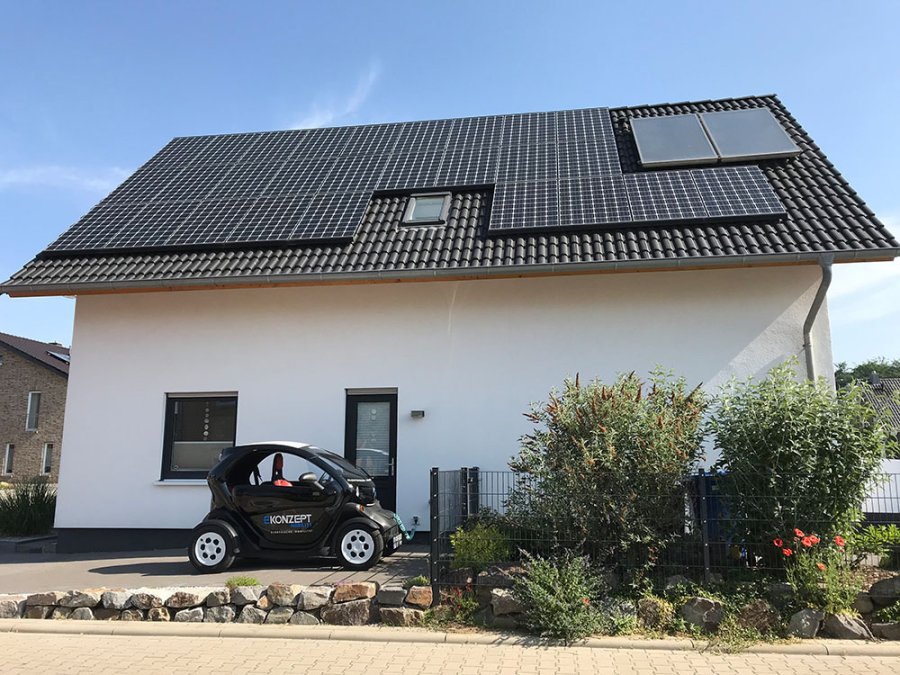 Haus mit Solaranlage und Elektroauto. Nachhaltige Energie für Zuhause.