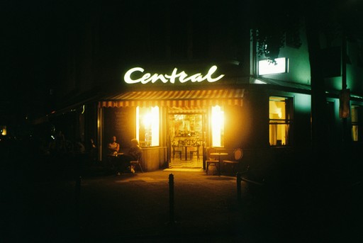 Central cafe illuminated at night with warm interior lights