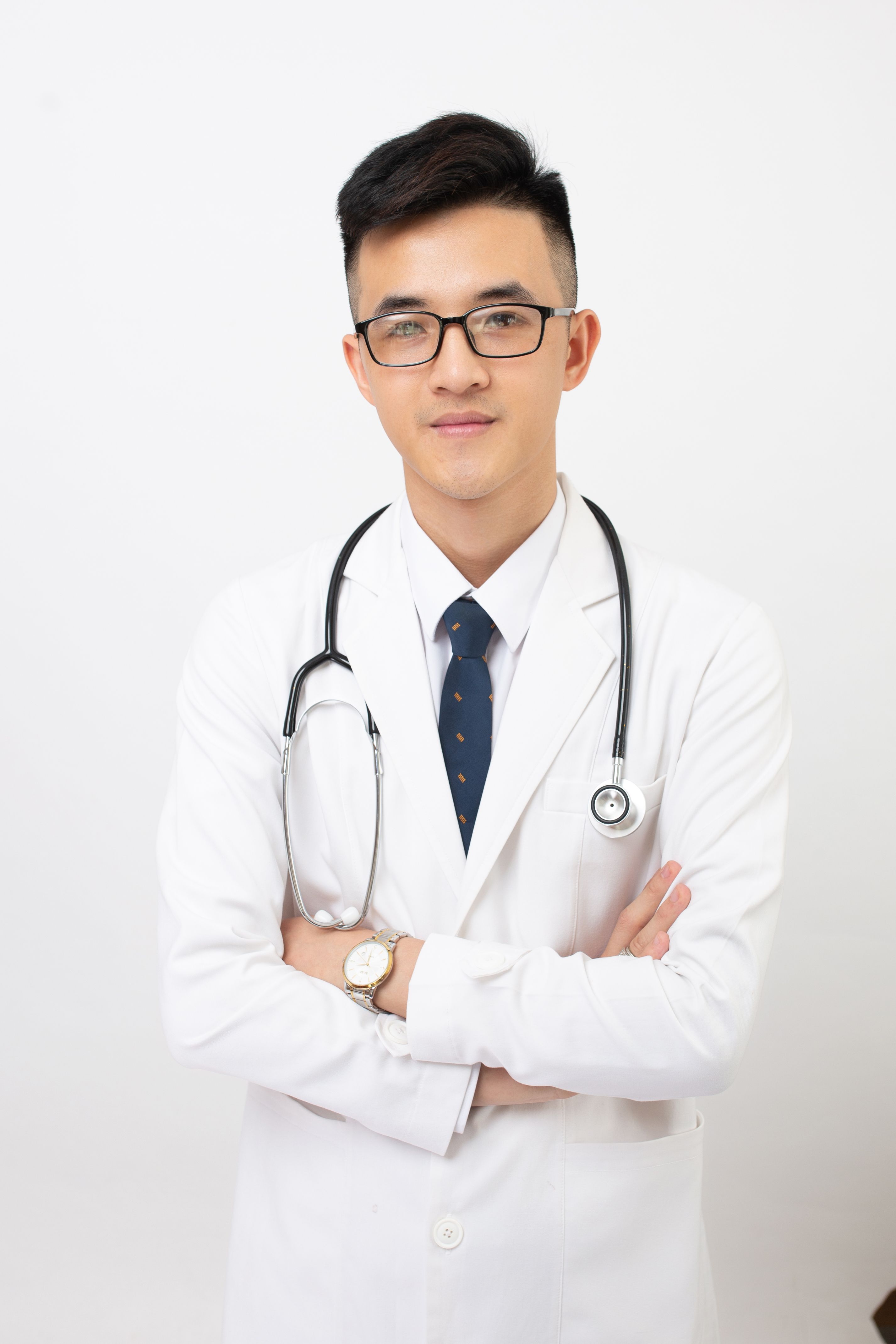 A smiling man in blue medical scrubs with a stethoscope around his neck