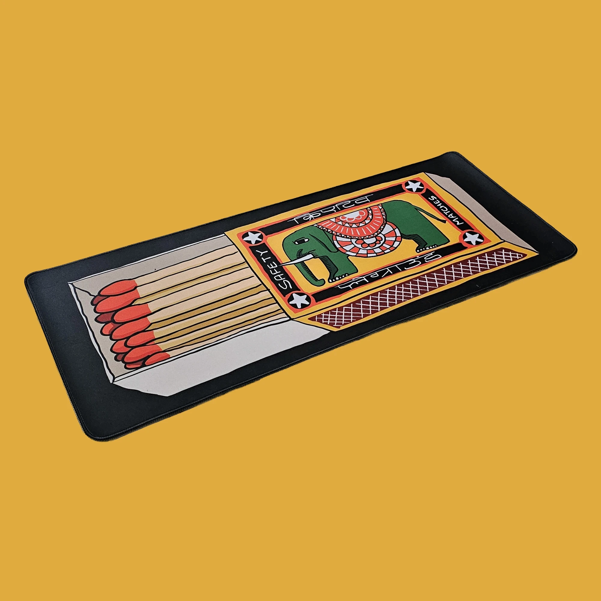 Matchbox deskmat on a mustard background