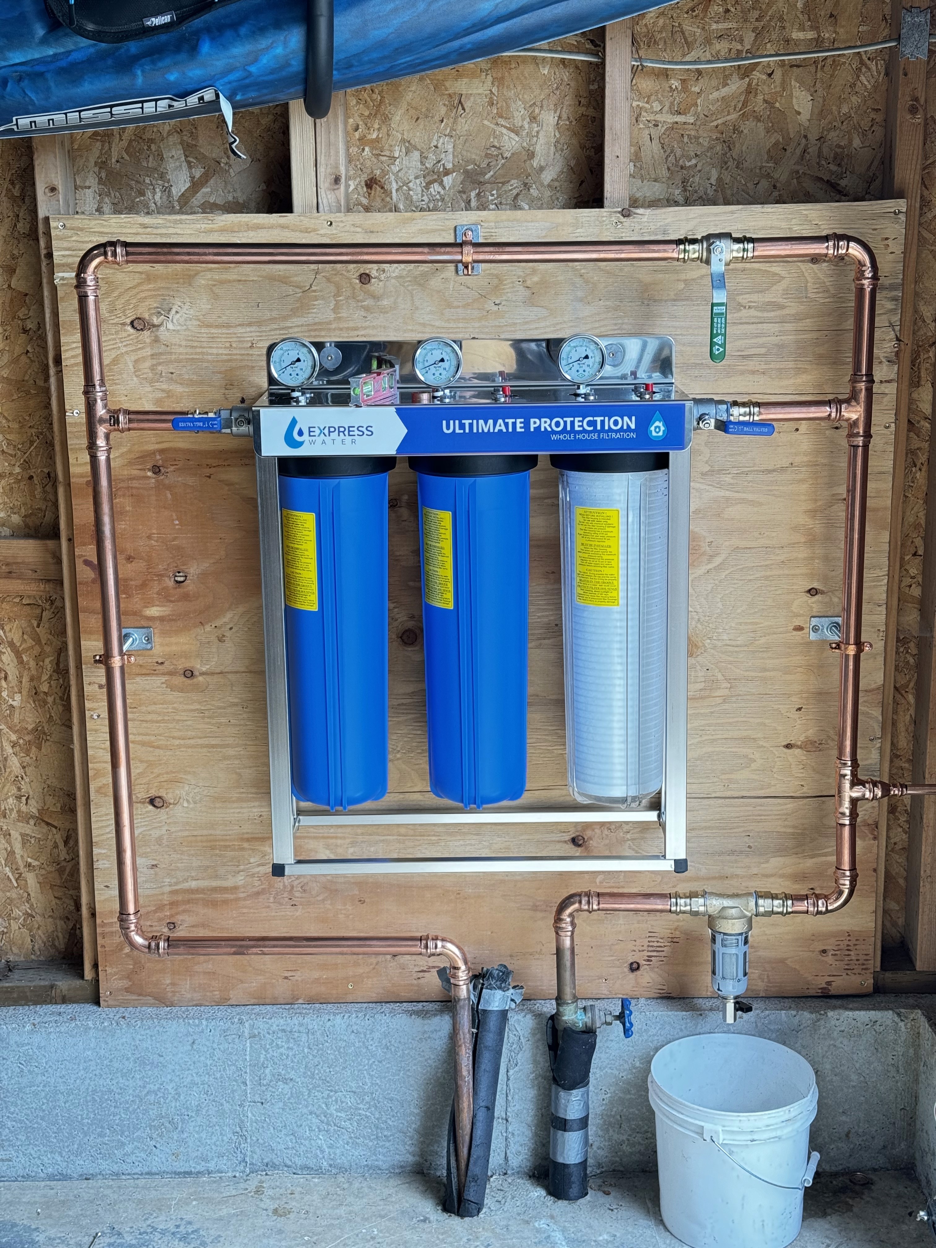 A winding road cuts through rocky terrain, surrounded by patches of green grass and illuminated by sunlight.