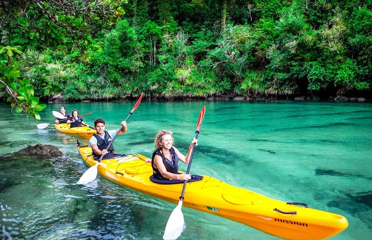 Tourists kayaking turquoise river