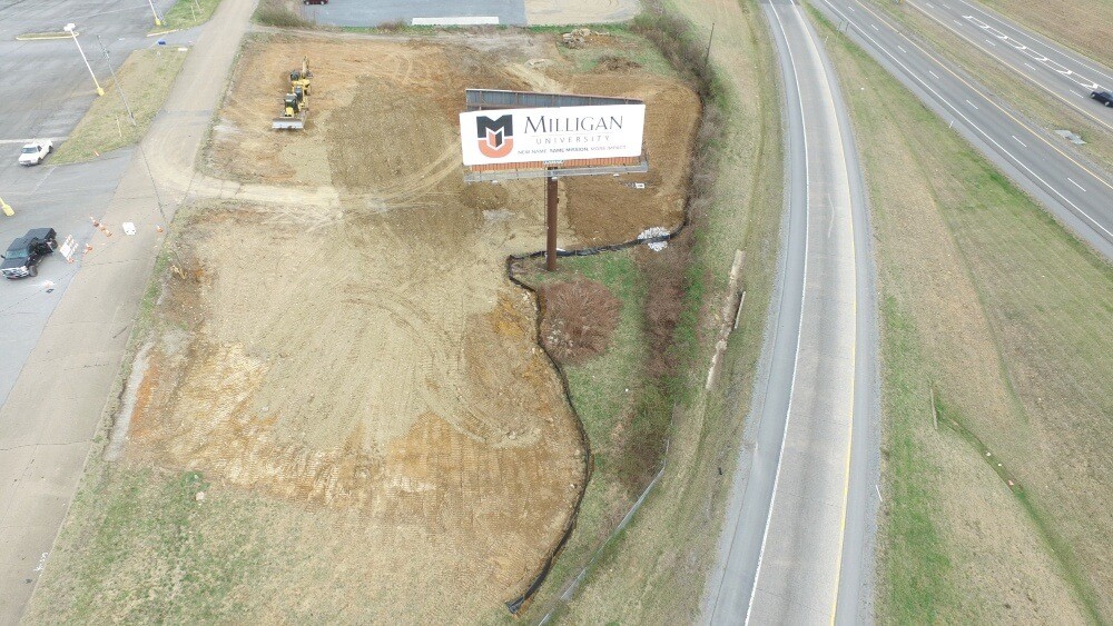 Drone overhead shot of lot being graded with billboard and road on one side.