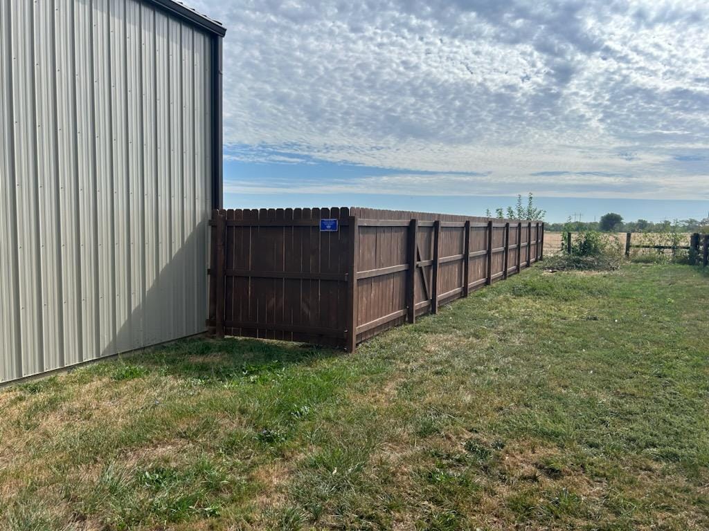 A serene outdoor lounge area with two chairs surrounded by lush greenery and natural light streaming in.