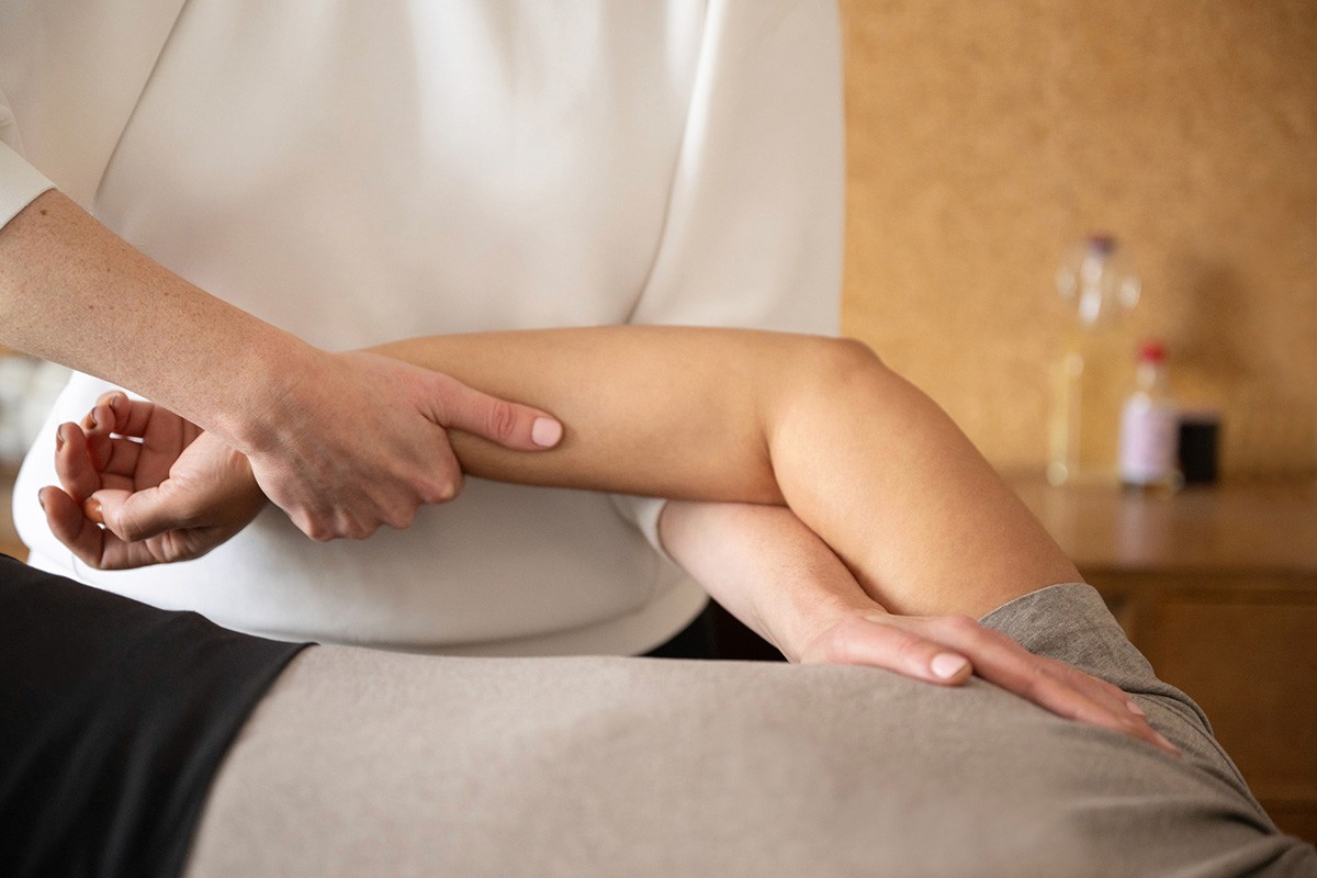 Ruth applying a Tui Na massage technique to a patient's arm to increase mobility and release muscle tension.