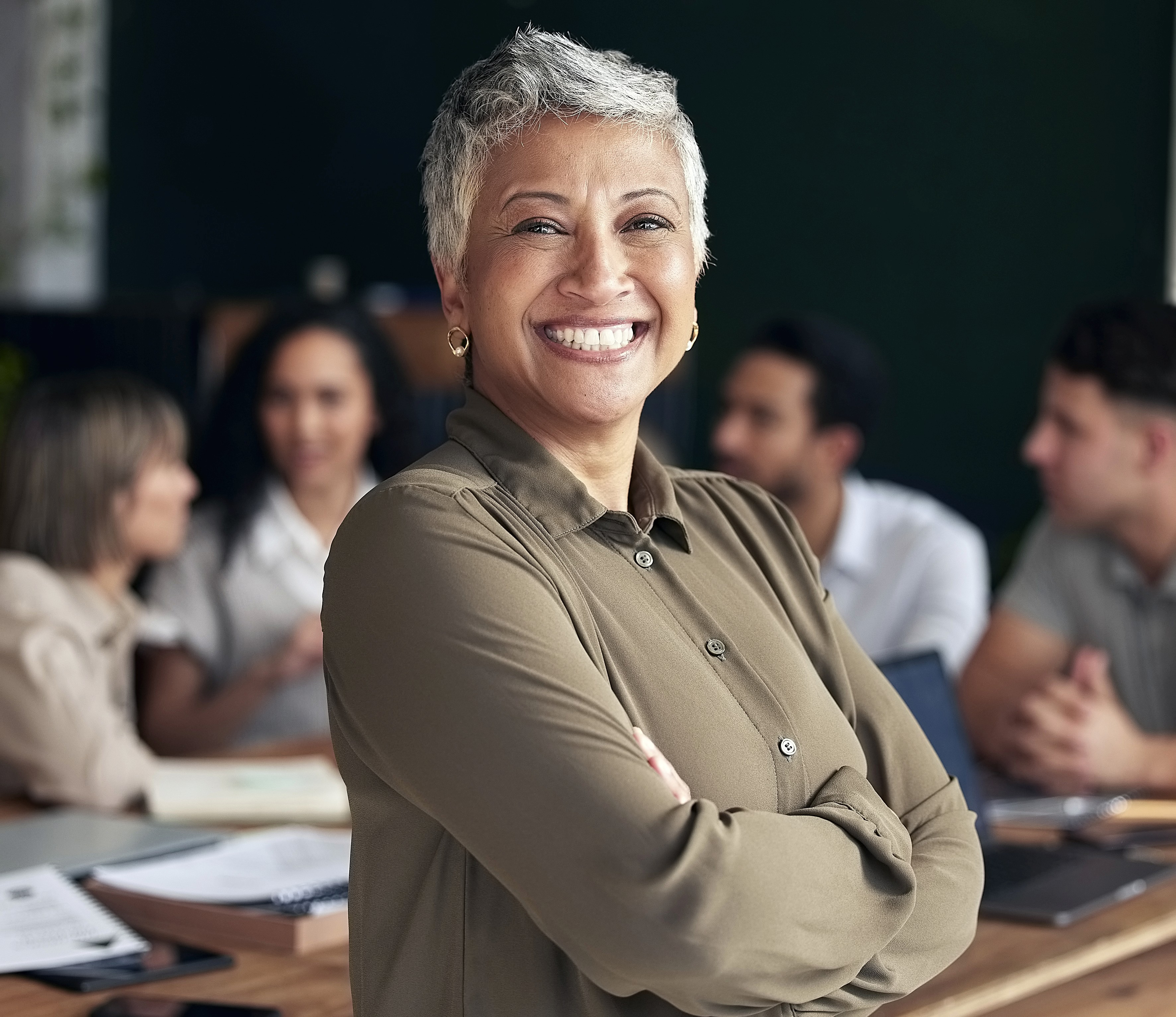 An image of a woman smiling as she shows joy because her school is compliant as her staff is trained in real world scenarios, thanks to Impact Suite.