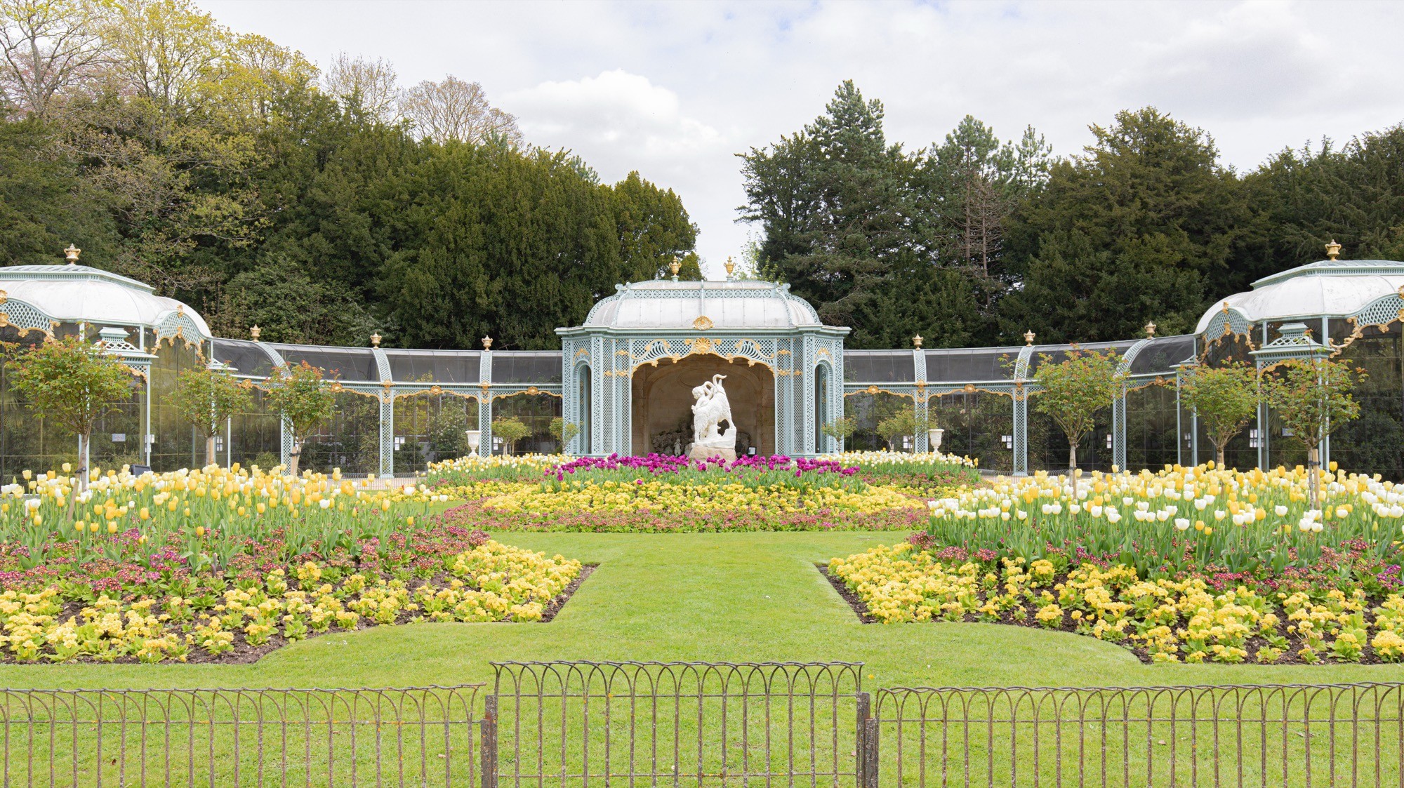 Two classic volkswagen beetles, one green, one cream.