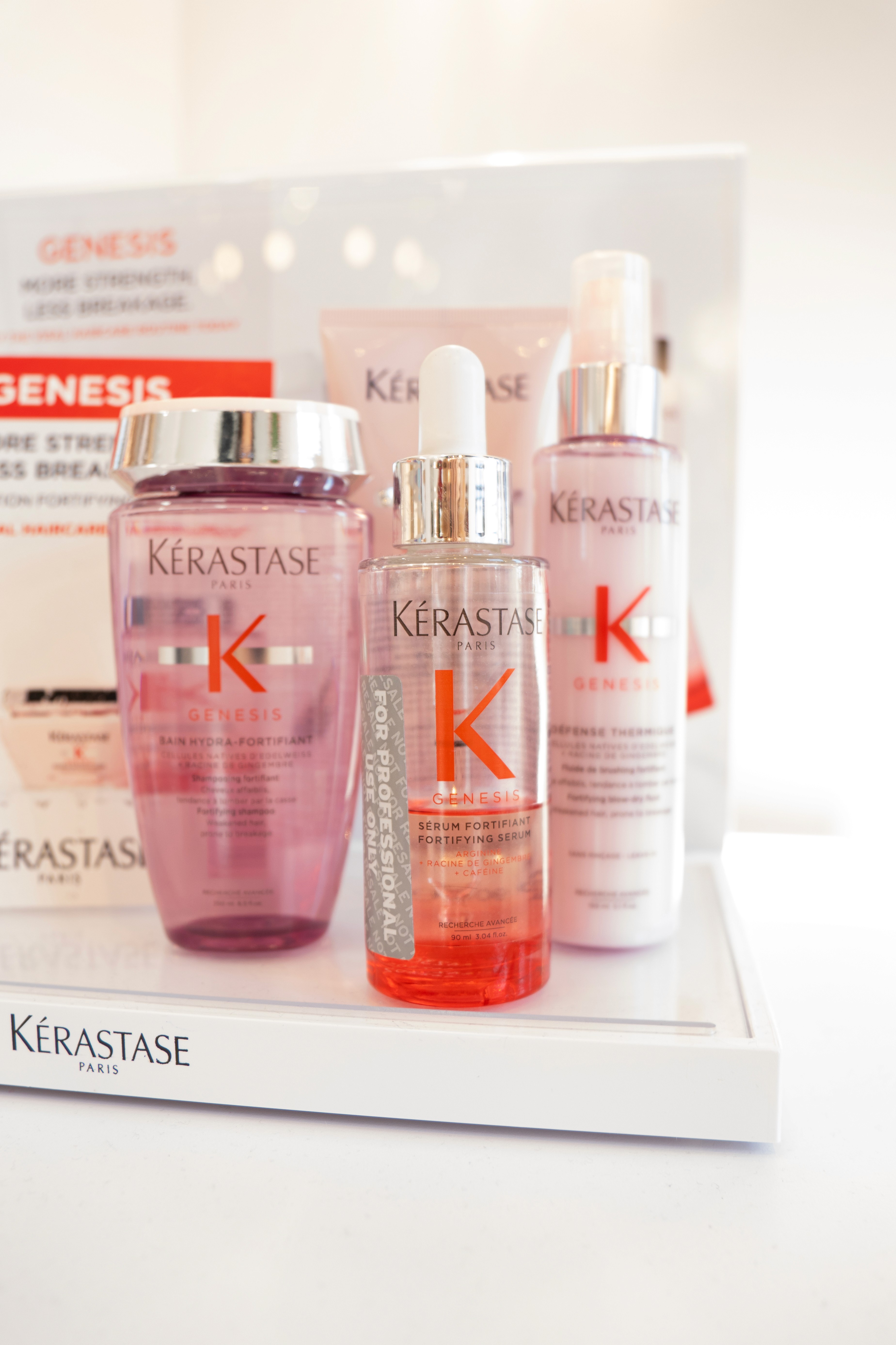 Smiling young man with short hair poses against a dark background, wearing a green button-up shirt.