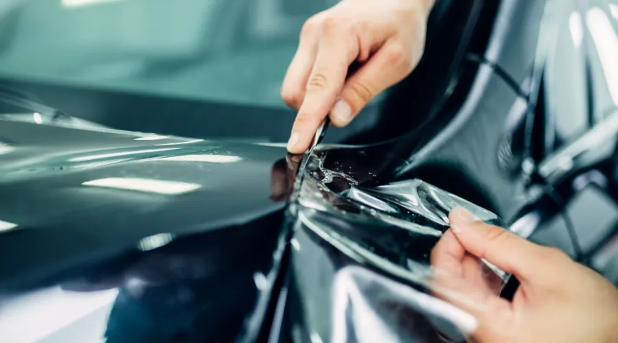Applying protective film to a vehicle's surface.