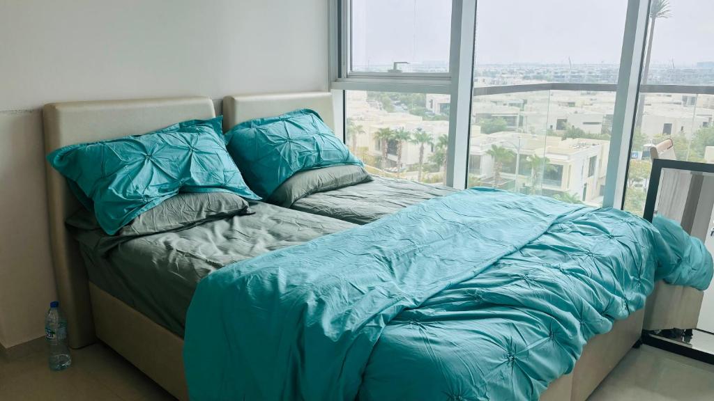 A bed with turquoise sheets and pillows positioned in front of a window, creating a serene atmosphere.