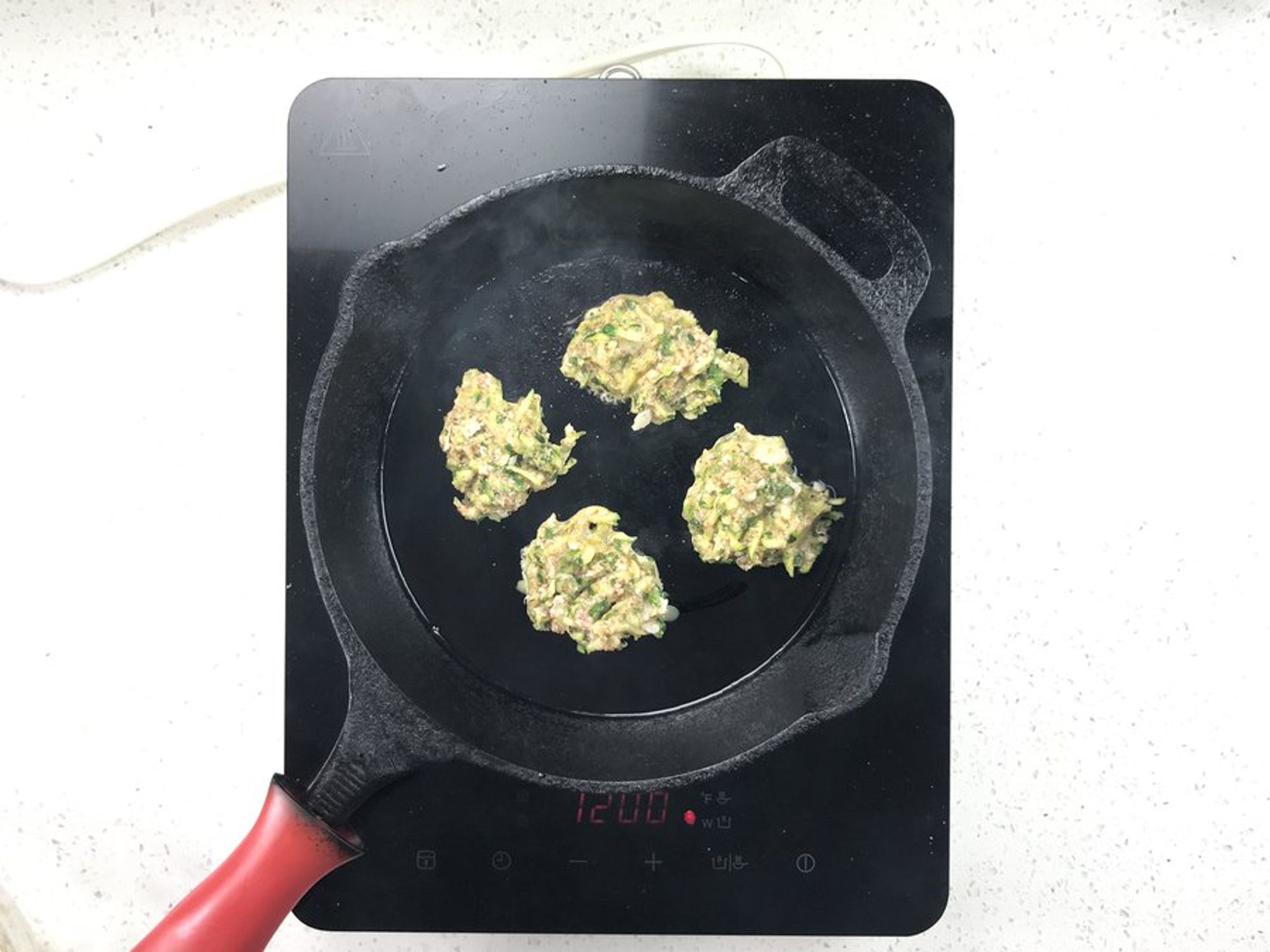 rounded zucchini batter in a hot pan