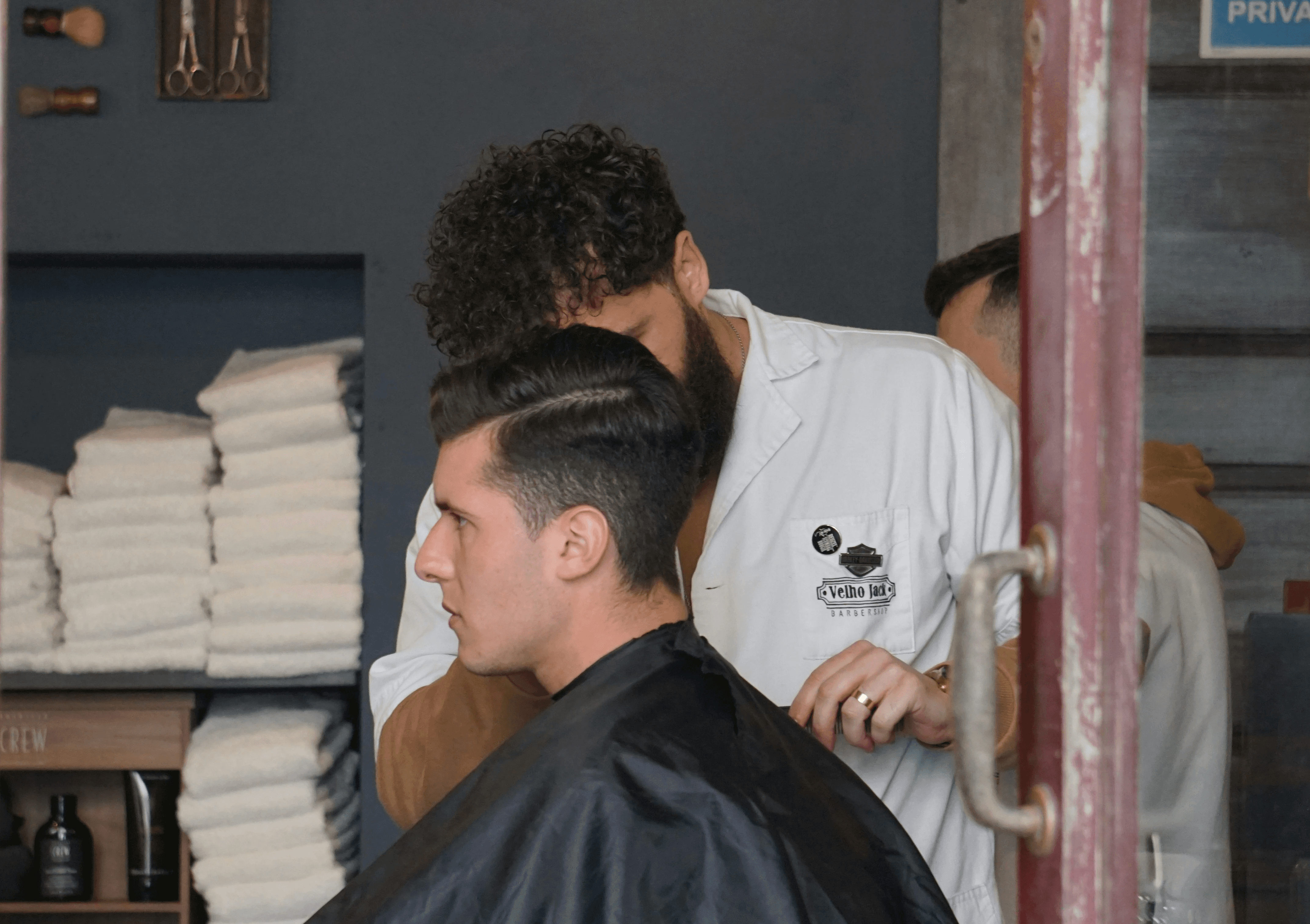 man in white shirt sitting on barber chair