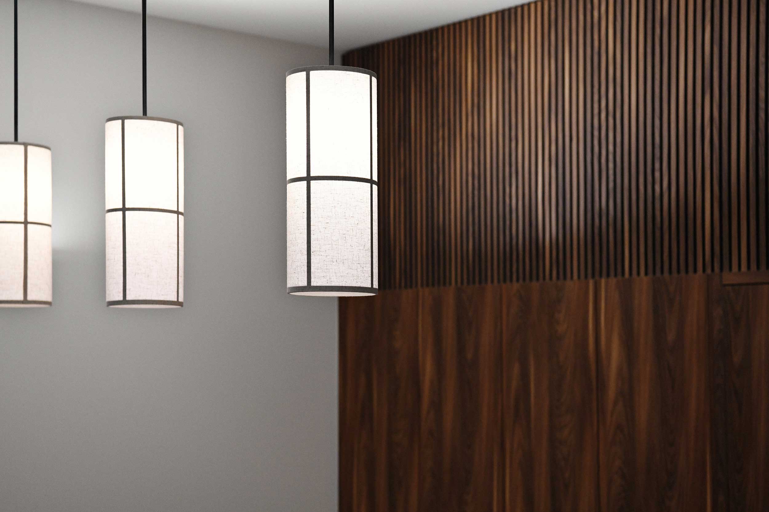 Detailaufnahme von drei zylindrischen Pendelleuchten vor einer vertikalen Holzlamellenwand in der Praxis SpinaMed.