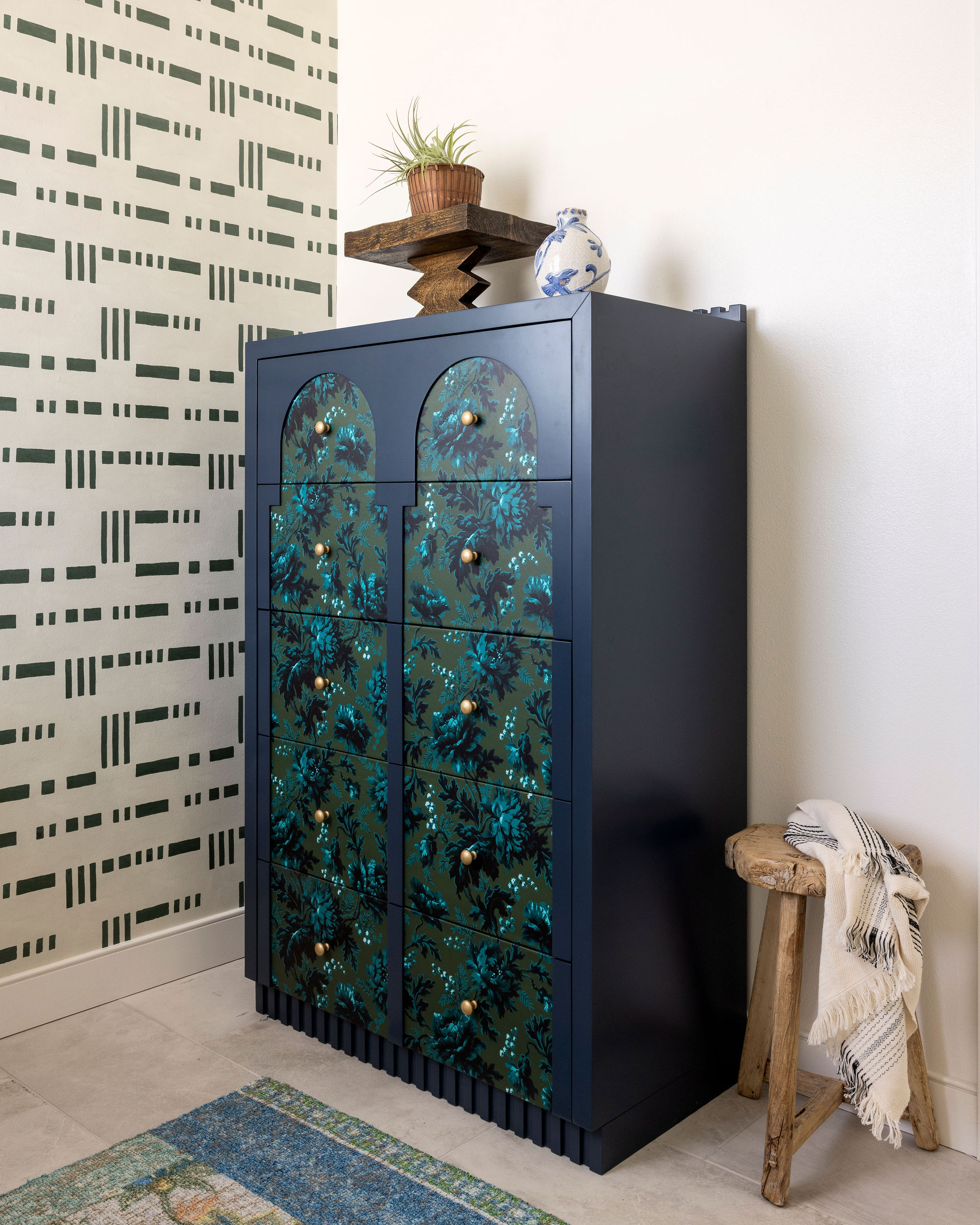 Sophisticated powder bath featuring a bold statement wallpaper, sleek modern fixtures, and a charming dresser that blends coastal charm with contemporary elegance.