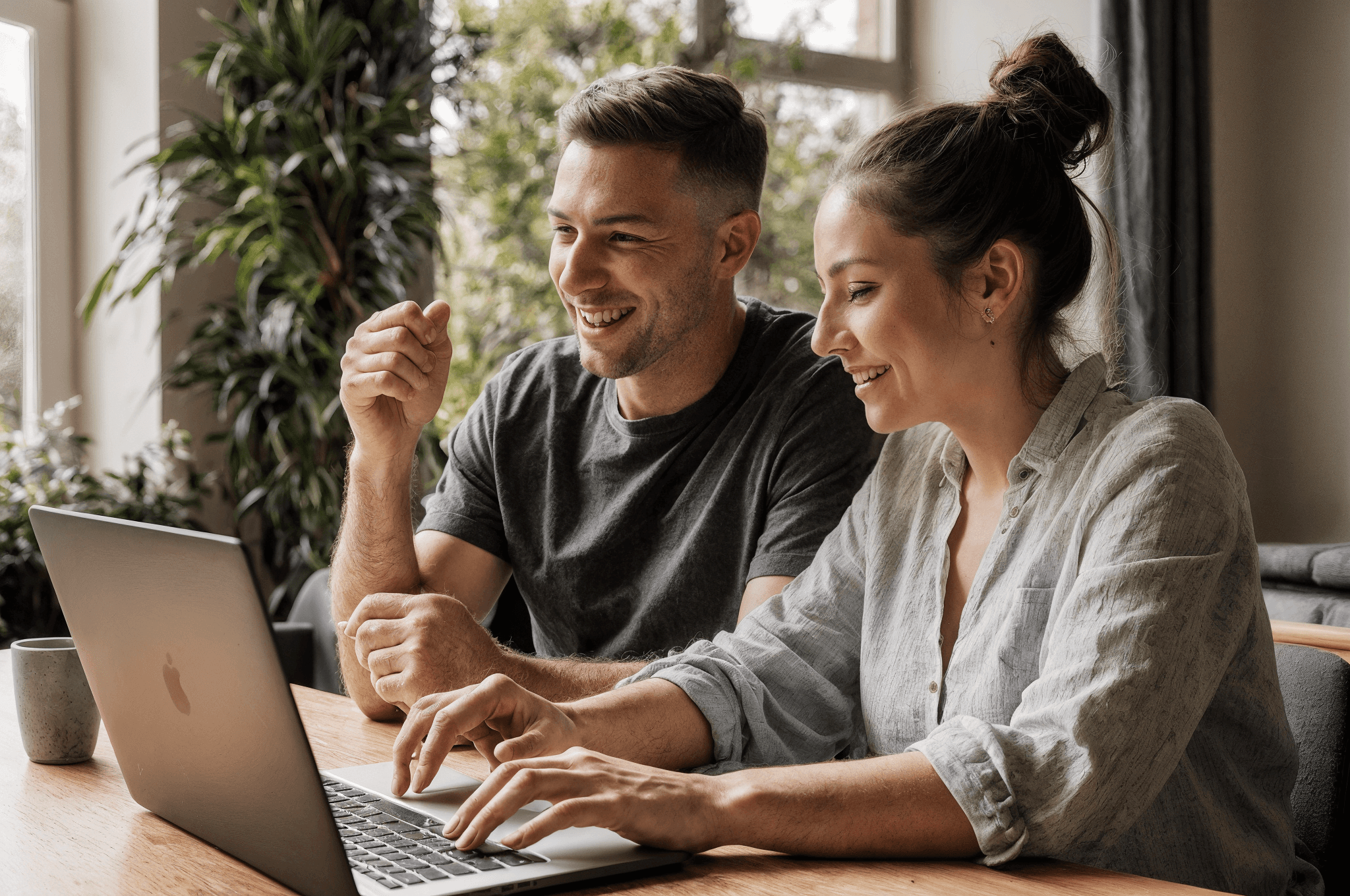 woman holding a phone and man looking at the phone. both are smiling