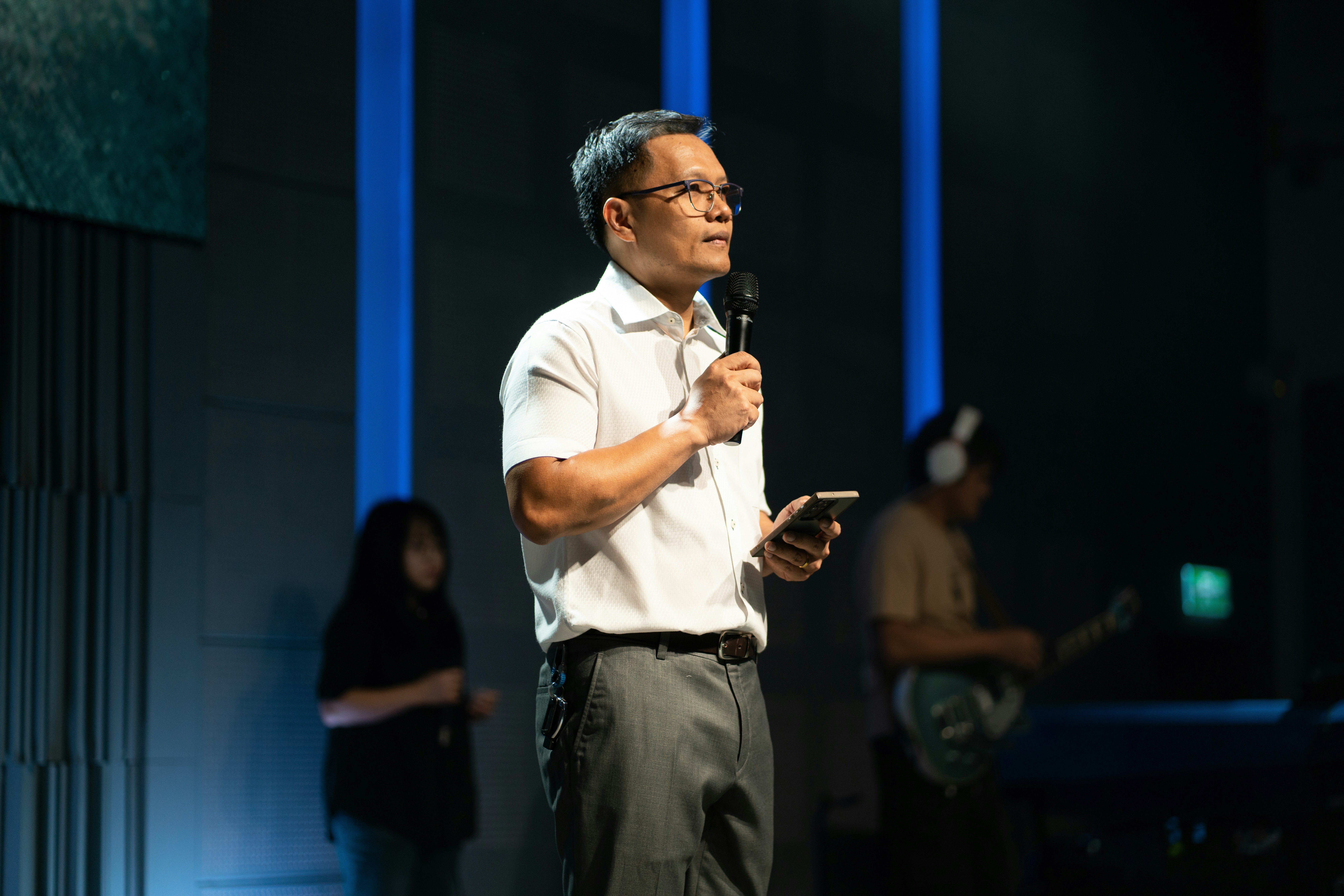 Man speaking into microphone holding phone on to phone