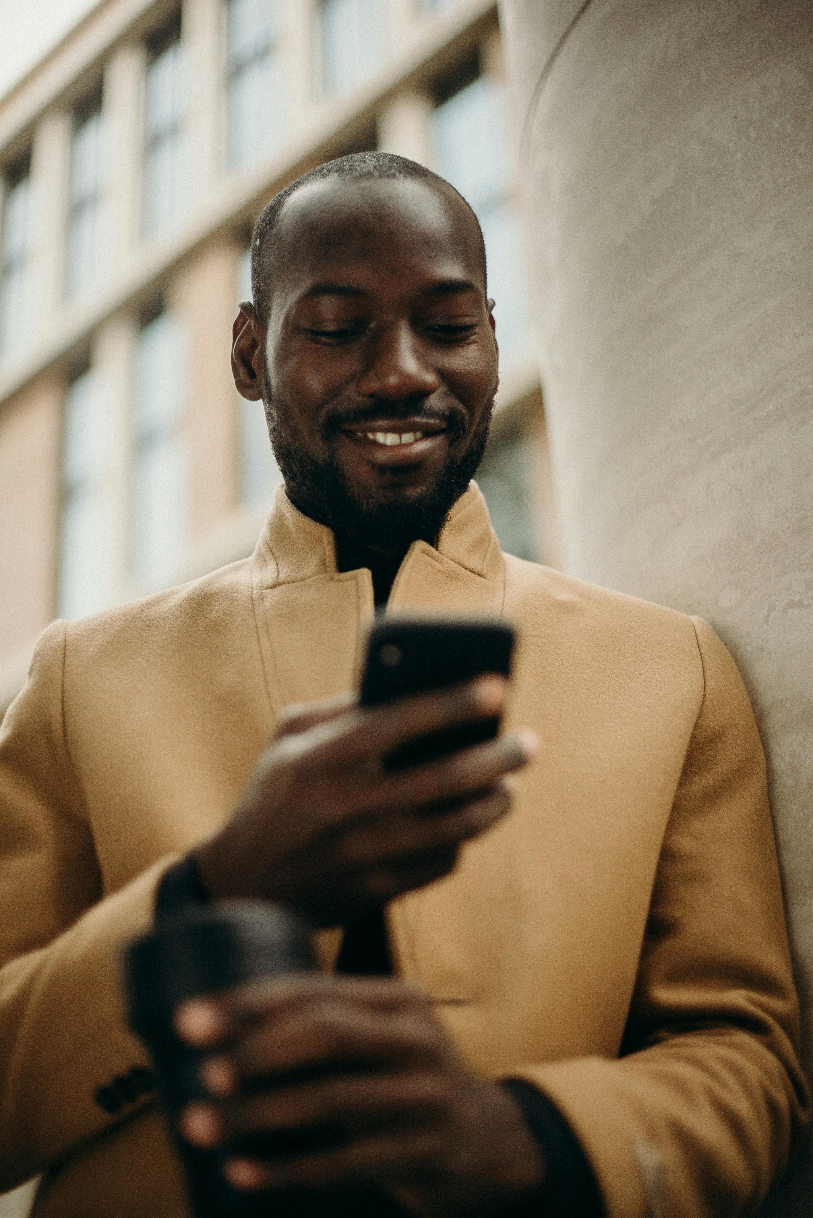 Business man smiling looking down at his phone