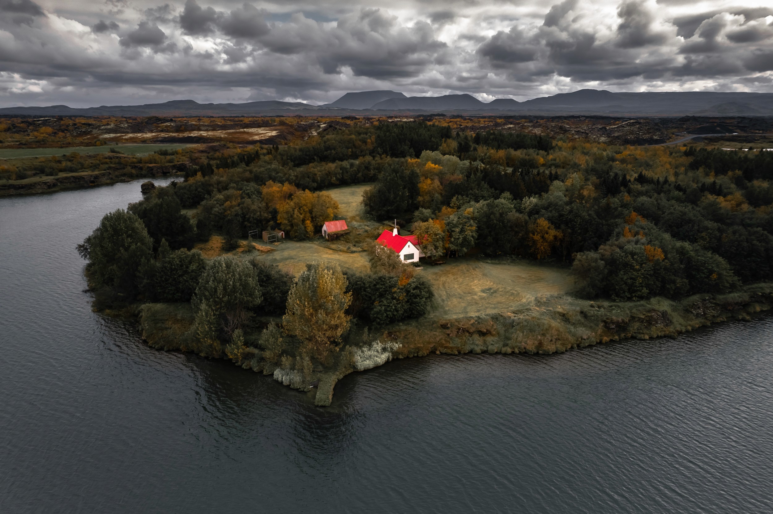 Drone view of a nice little red-roofed house off the side of the road in Iceland