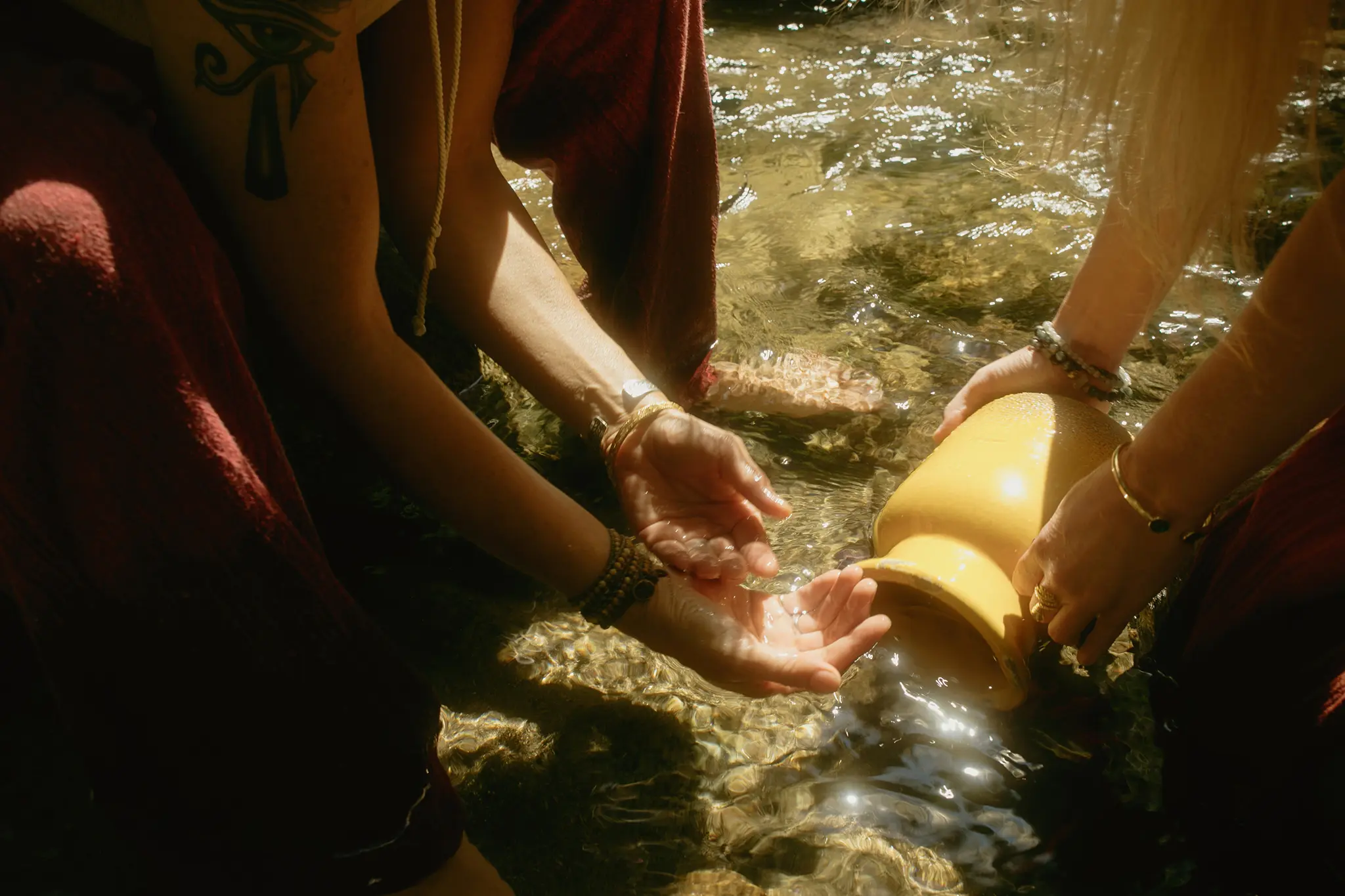 Ceremonial facilitator offering psilocybin medicine to participant in nature at Tree of Life Temple retreat