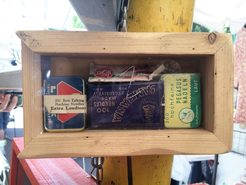 A photo of a wooden box with a glass window on a side that contains some household items.