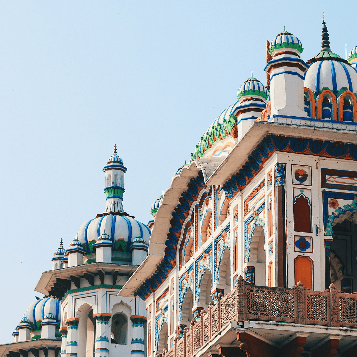 Ornate domed temple with blue and white decorative details against a clear sky, Nepal