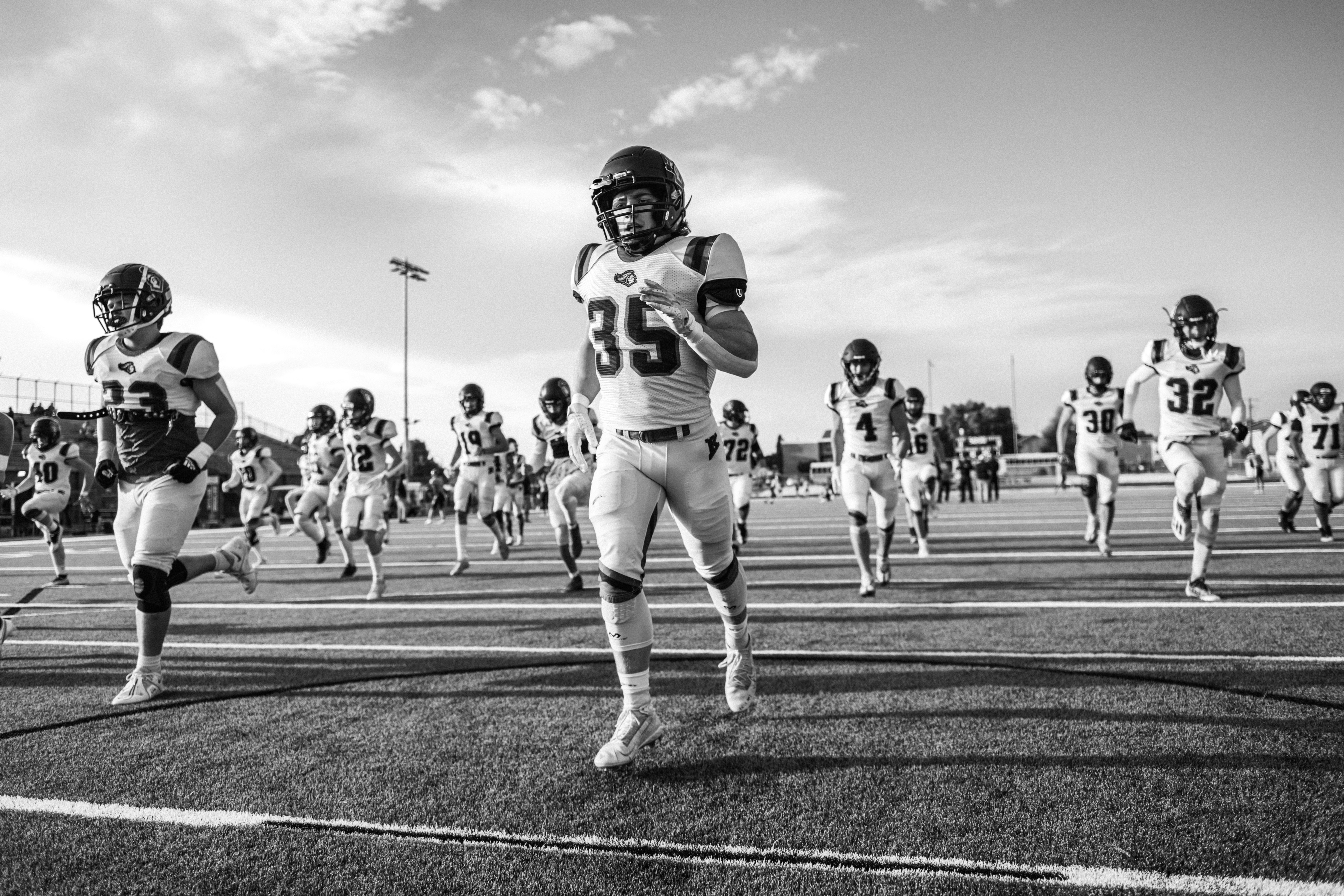 Football team running onto the field during a game.