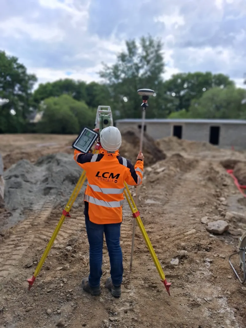 Technicien utilisant un tachéomètre et GPS sur chantier de construction BTP